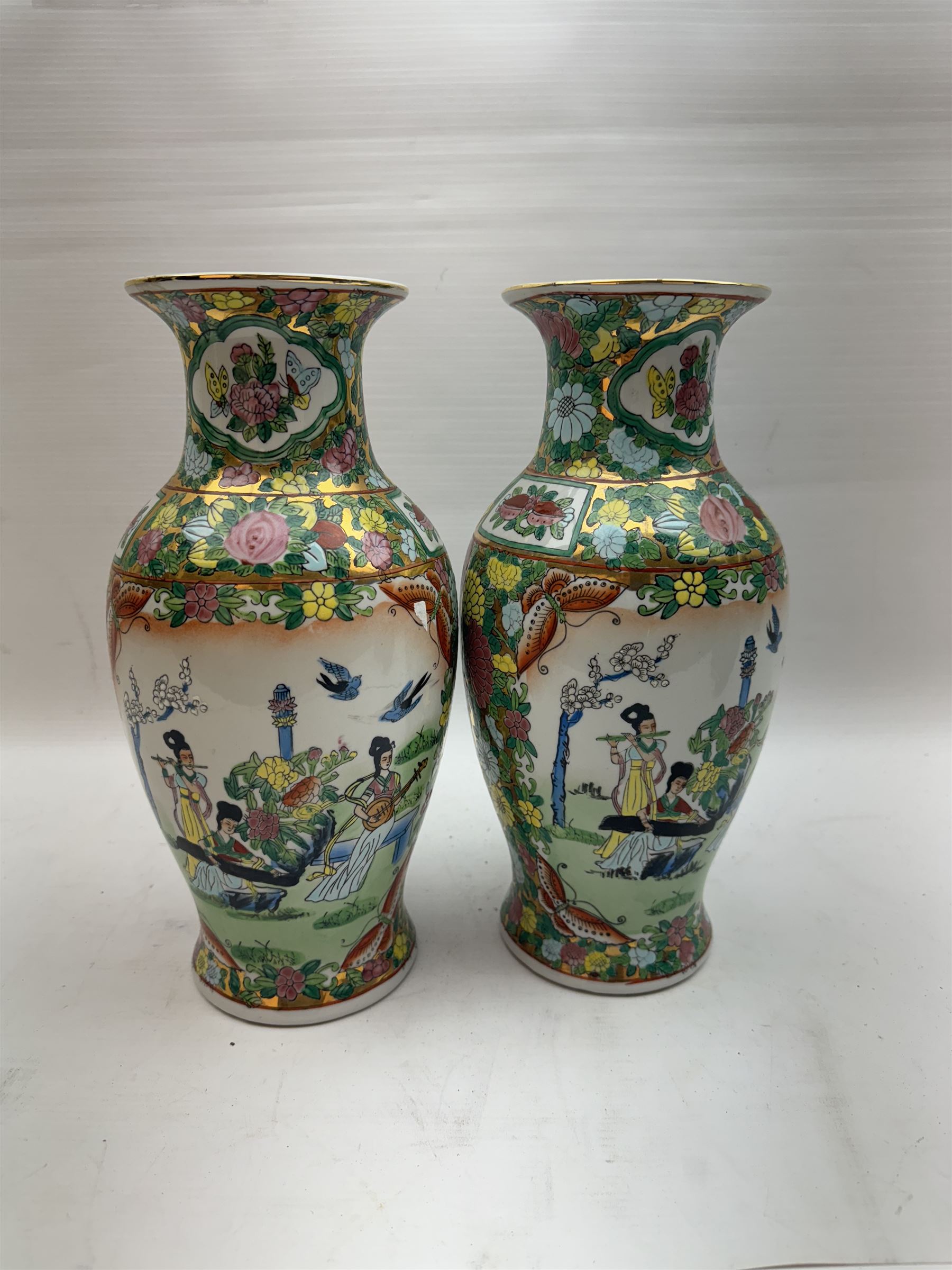 Pair of Famille Rose vases of baluster form, decorated with panels depicting musicians, H30cm