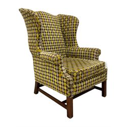 Georgian design mahogany framed wingback armchair, upholstered in spotted fabric in shades of grey and green, on moulded square supports united by stretchers 