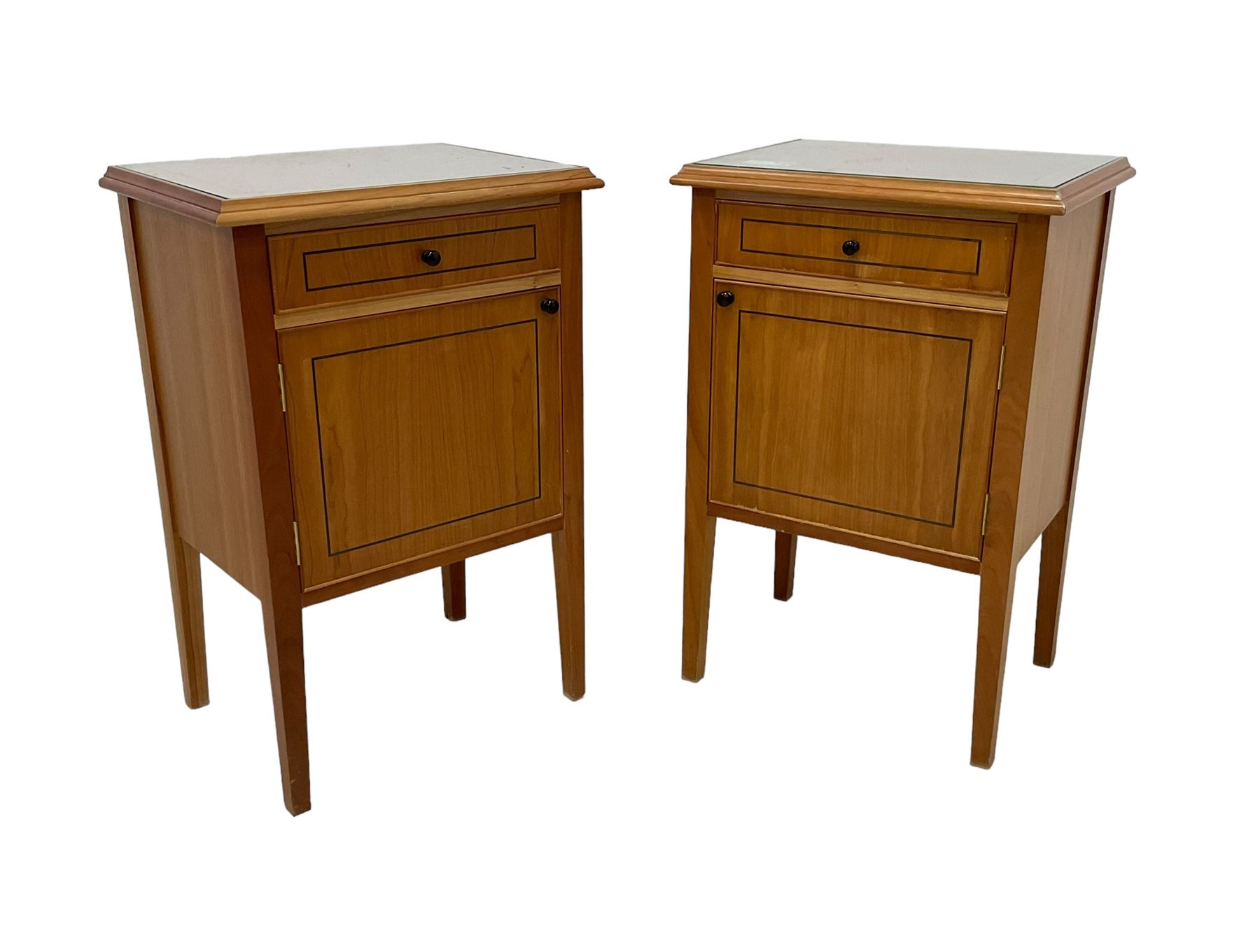 Pair of contemporary cherry wood bedside cupboards, inset glass top in moulded frame, fitted with single drawer over cupboard, on square tapering supports 