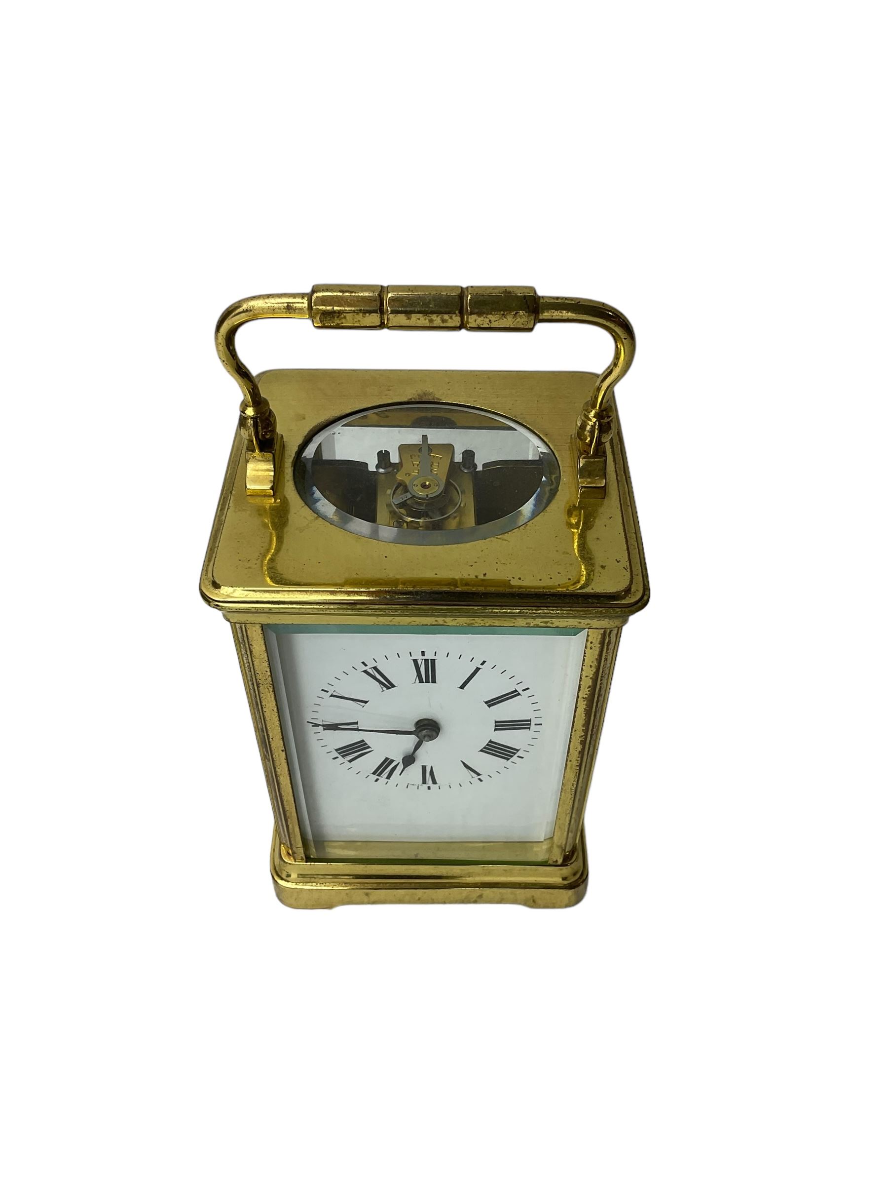 20th century -  8-day striking carriage clock in a corniche case, with an enamel dial , Roman numerals, minute track and steel spade hands, twin train going barrel movement with a lever platform escapement and rack striking, sounding the hours and half hours on a coiled gong.  With key.