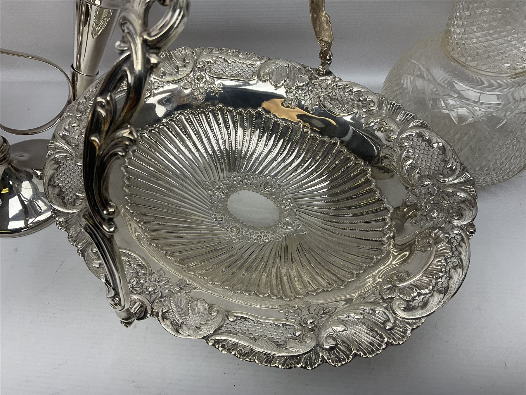 Silver plated three branch epergne, together with a silver plated cut glass claret jug, and silver plated embossed swing handled basket, epergne H30.5cm