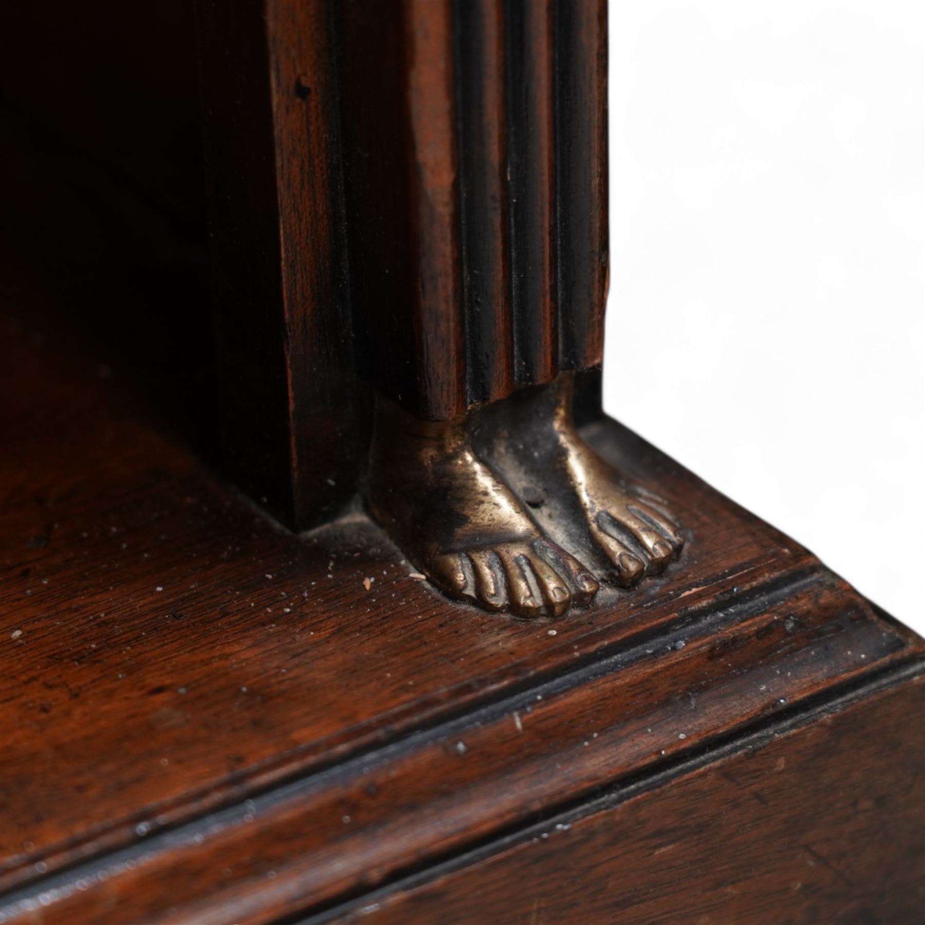 Pair of Neoclassical Empire design mahogany open bookcases, the rectangular top with reeded edge over a plain frieze decorated with a brass mount of the Greek god Hermes, the single shelf flanked by reeded square pilaster uprights, surmounted by a brass capital in the form of a female Egyptian bust, with human feet terminals, lower moulded edge on skirted base