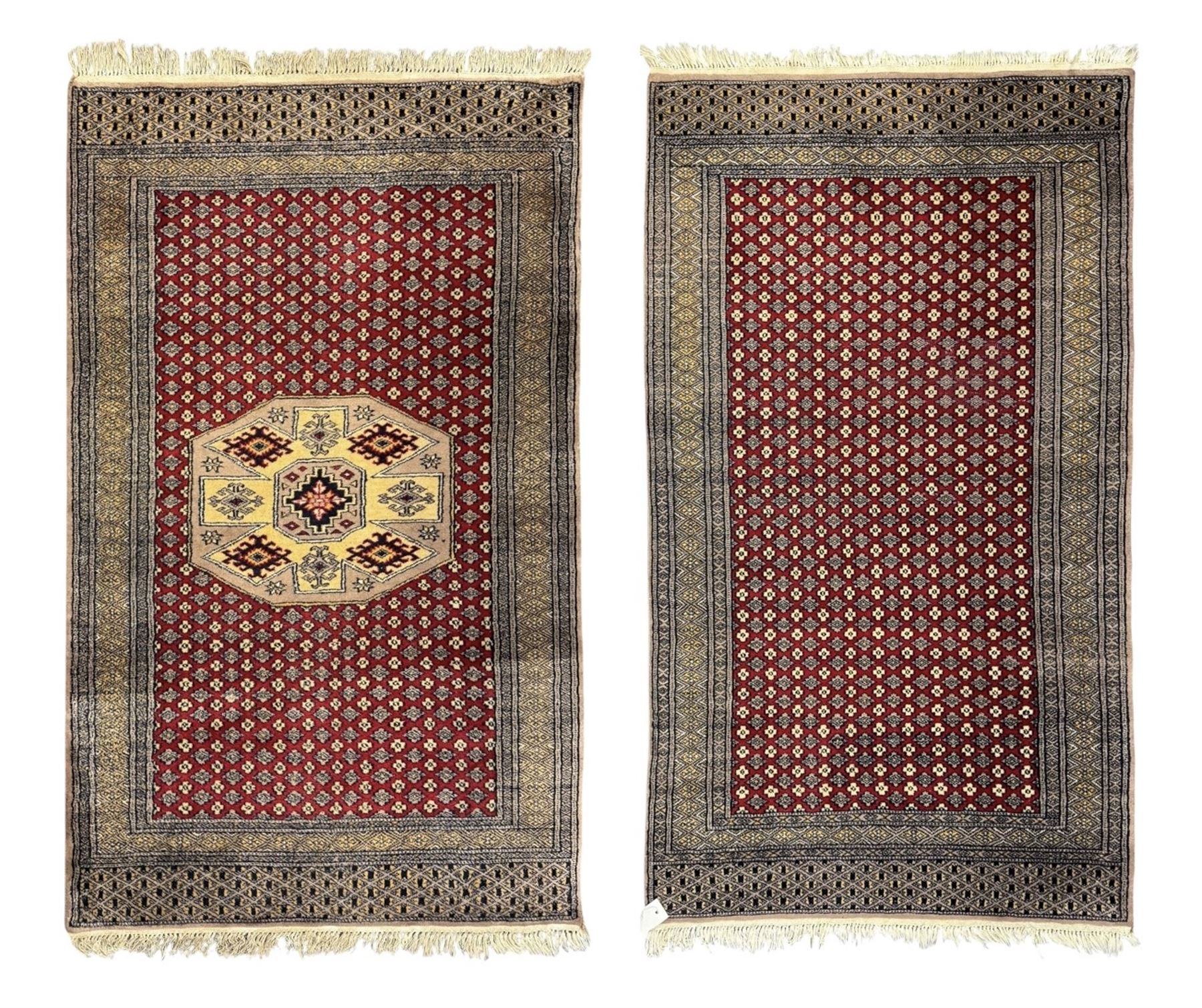 Pakistani Kashan hand-knotted rug with a central medallion and intricate geometric floral patterns, set against a red field and framed by a multi-band border; Pakistani Kashan rug with a repeating floral motif across the red field, enclosed by a detailed geometric border in complementary tones (2)