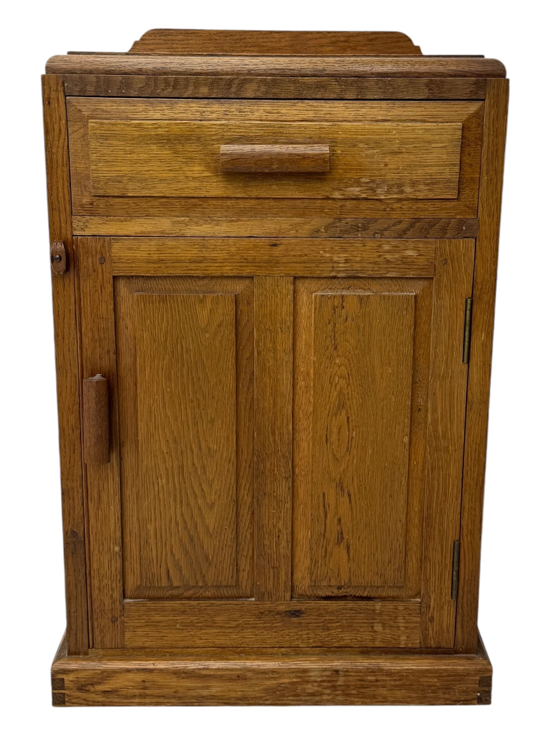 Arts & Crafts period oak bedside cupboard, raised back over moulded top, fitted with single drawer over panelled cupboard, panelled sides, on chamfered plinth base 