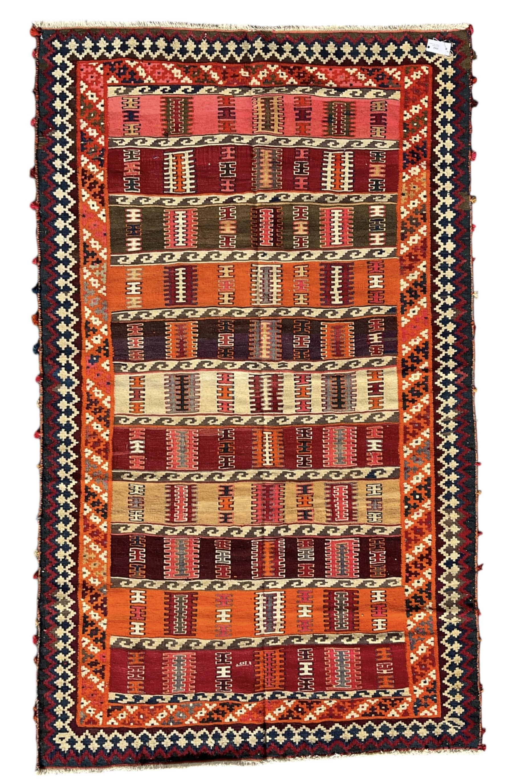 Southwest Persian Qashqai Kilim ground rug, featuring a series of horizontal striped panels each filled with intricate geometric designs, enclosed by a dark blue and ivory border with stylised star and zigzag motifs