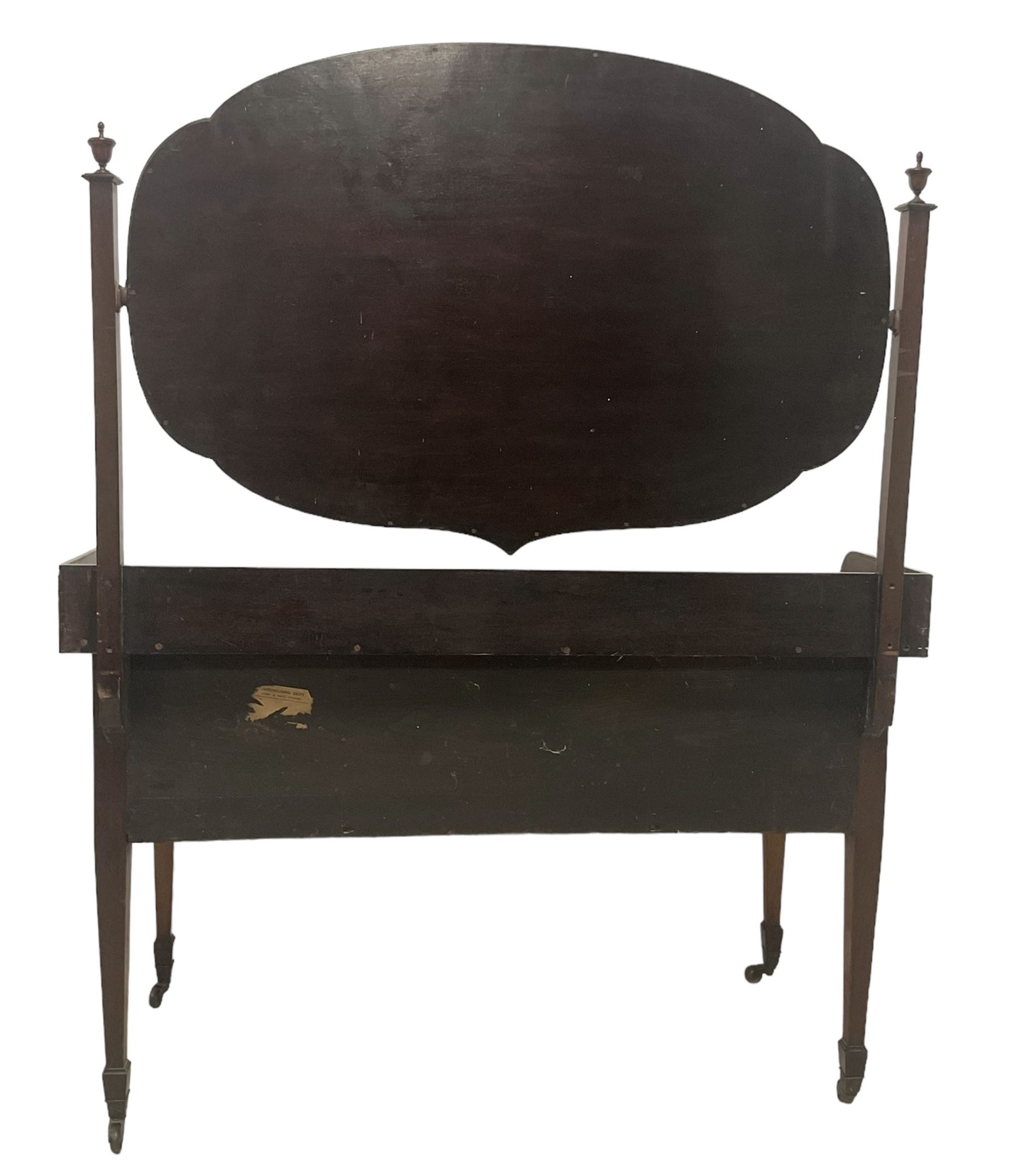 Edwardian inlaid mahogany kneehole dressing table, raised shaped oval bevelled mirror back, fitted with five drawers with banding and stringing, on square tapering supports with castors