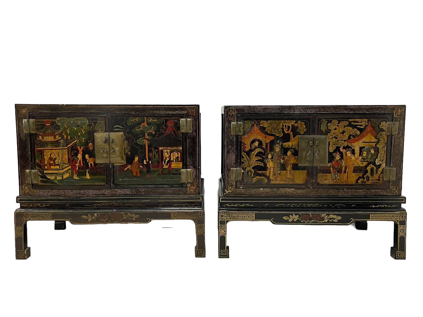 Pair of early 20th century Chinese ebonised and lacquered wood cabinets, the top decorated with dragons over lapping waves within a gilt patterned panel, the surrounding band decorated with Chinese symbols and flowerheads, enclosed by two doors each with village scenes with pagodas, figures and trees, the panelled sides decorated with a figure riding a dragon on stands with gilt decorated 