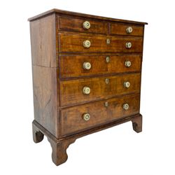 George I walnut chest, moulded rectangular top with book-matched veneers within crossbanding, fitted with two short over four long graduating drawers, moulded drawer fronts with brass handles, on bracket feet, the chest will split into two sections 