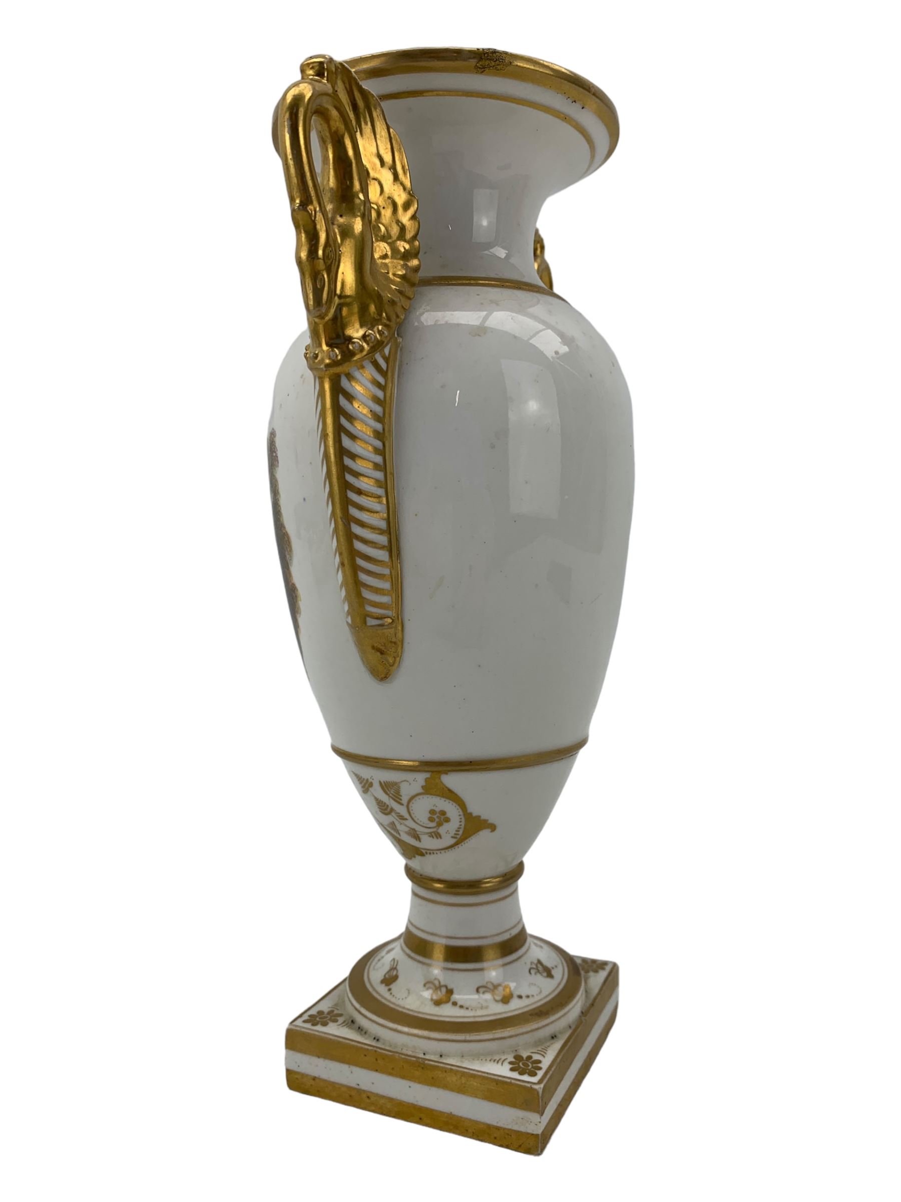 Early 19th century Derby vase, of campana urn form, decorated to one side with a hand painted reserve of a basket of flowers, within a scroll gilt border and twin serpent form handles, H20.5cm together with a Bloor Derby vase, hand painted with figures in a wooded landscape, with twin gilt swan form handles, upon a square pedestal foot, H25cm (2)