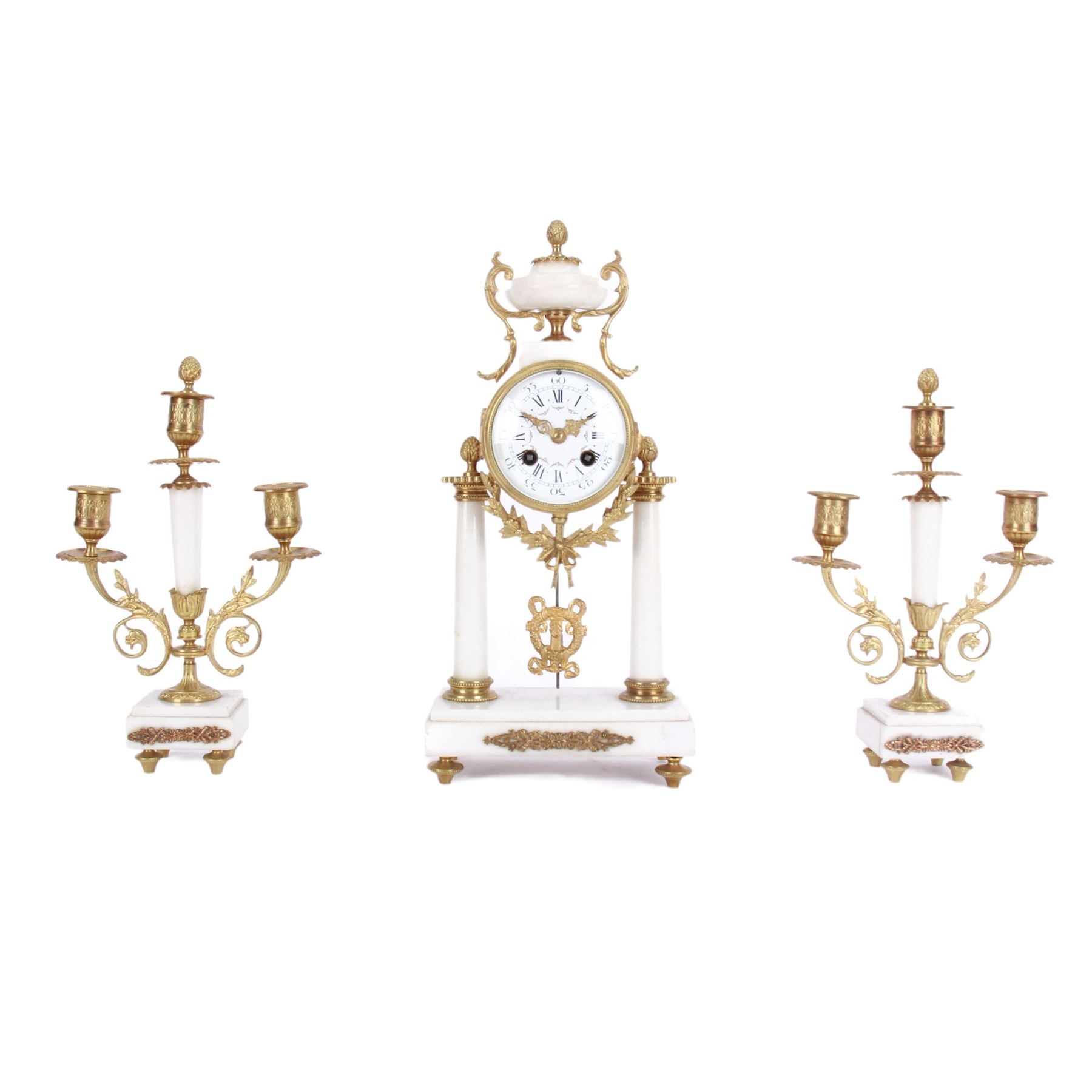 French - Louis XV style white marble and gilt mounted 8-day portico clock garniture c1905, drum movement surmounted by an oval shaped urn, supported on a pair of tapered column supports and raised on a rectangular plinth base, white enamel dial with floral garlands and Arabic numerals, Louis XV style gilt hands within a glazed bezel, twin train countwheel striking movement, striking the hours and half hours on a bell, with a pair of conforming three light candelabra, decorative matching pendulum and key.