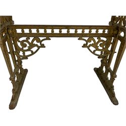 Pair of 19th century cast iron entrance tables, rectangular marble top over ornate gilt bases with scrolling foliate design and sledge feet, united by balustrade stretcher with scroll spandrels