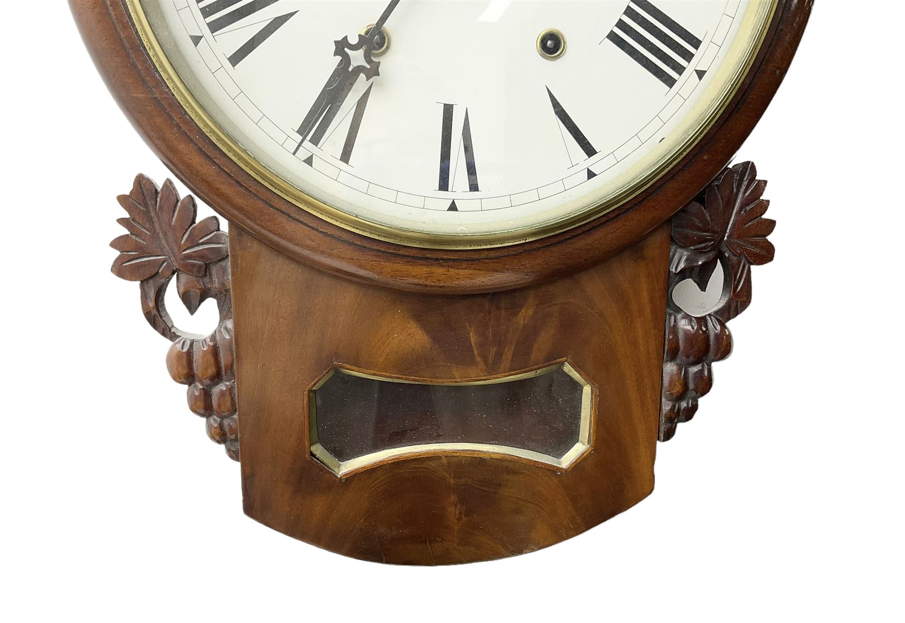 Late 19th century 8-day  drop dial wall clock in a mahogany case, carved ear pieces and glazed pendulum viewing glass, 12” painted dial with Roman numerals and Maltese steel hands, twin train going barrel movement striking the hours on a bell. No pendulum or key.