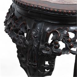 Early 20th century Chinese hardwood and marble top jardiniere or urn stand, shaped circular top with central marble inset and bead edge, over pierced and carved foliate rails with blossom design, the cabriole supports carved with trailing vines and leafage, united by X-stretcher on shaped claw feet