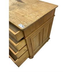 Waxed pine twin pedestal desk, rectangular top over nine drawers, on compressed bun feet 