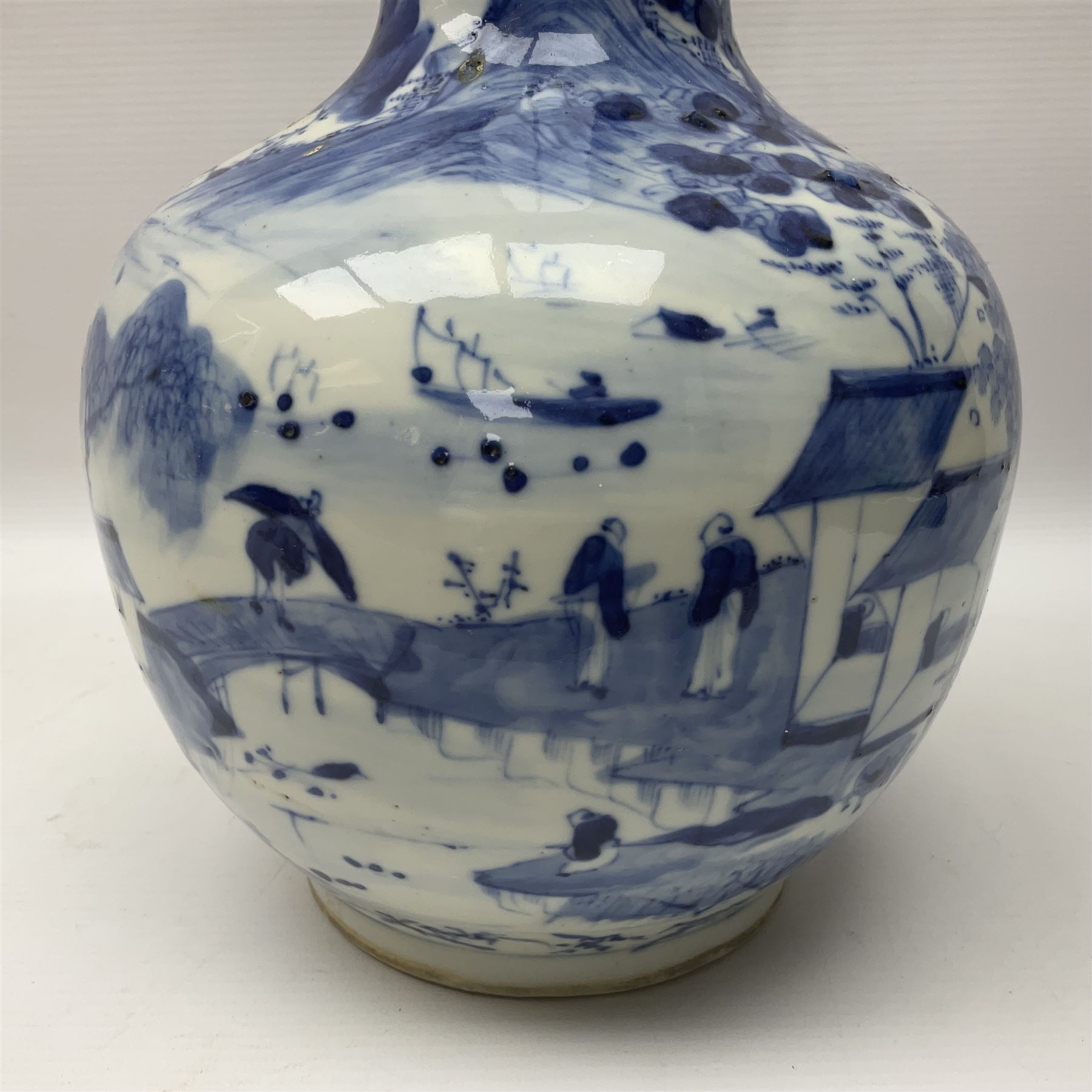 Late 18th/early 19th century Chinese blue and white bottle vase, decorated with a landscape scene containing dwellings, prunus and pine trees, boats and bridges, and populated with figures, with character mark beneath, H35cm