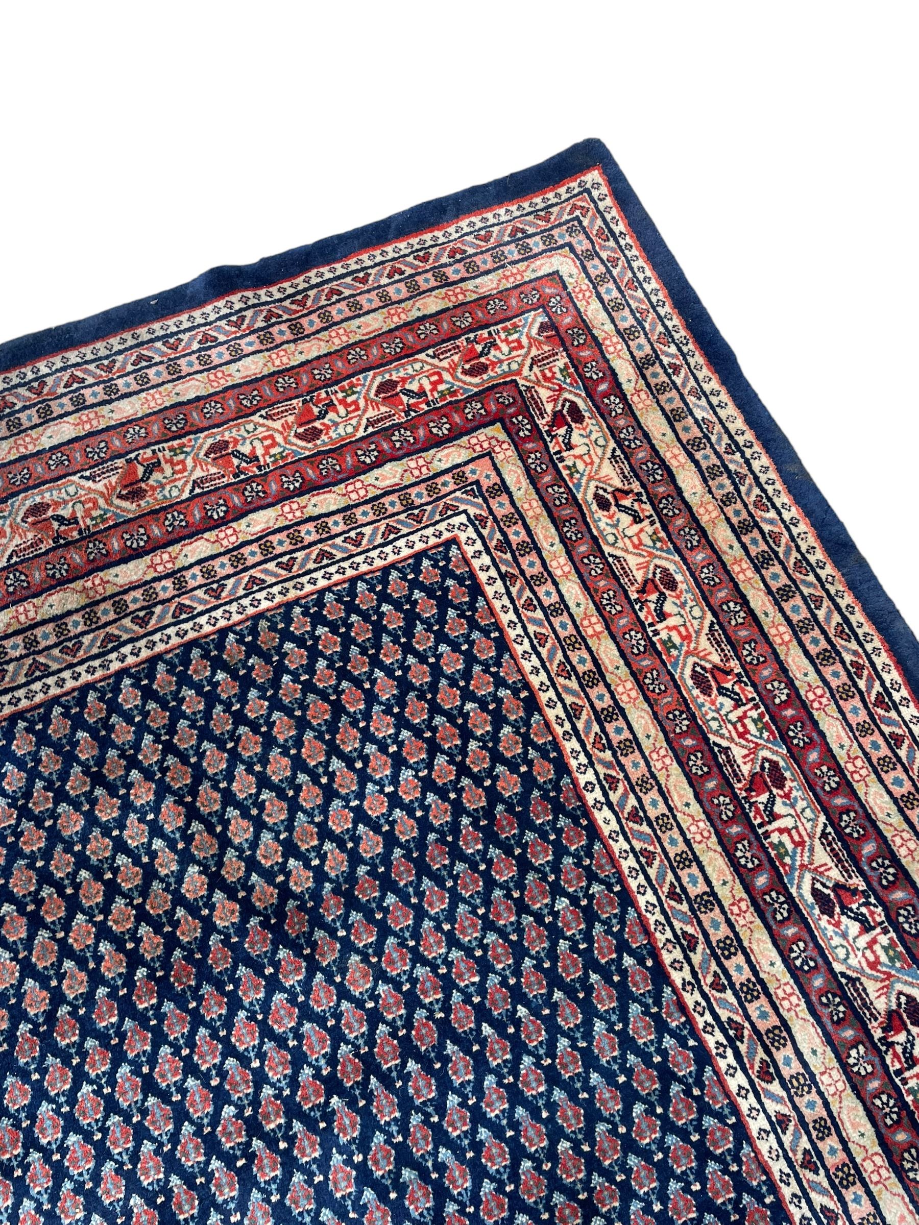 Large North-West Persian Arrak indigo ground carpet, the field decorated all-over with small Boteh motifs, multiple band border decorated with repeating geometric designs