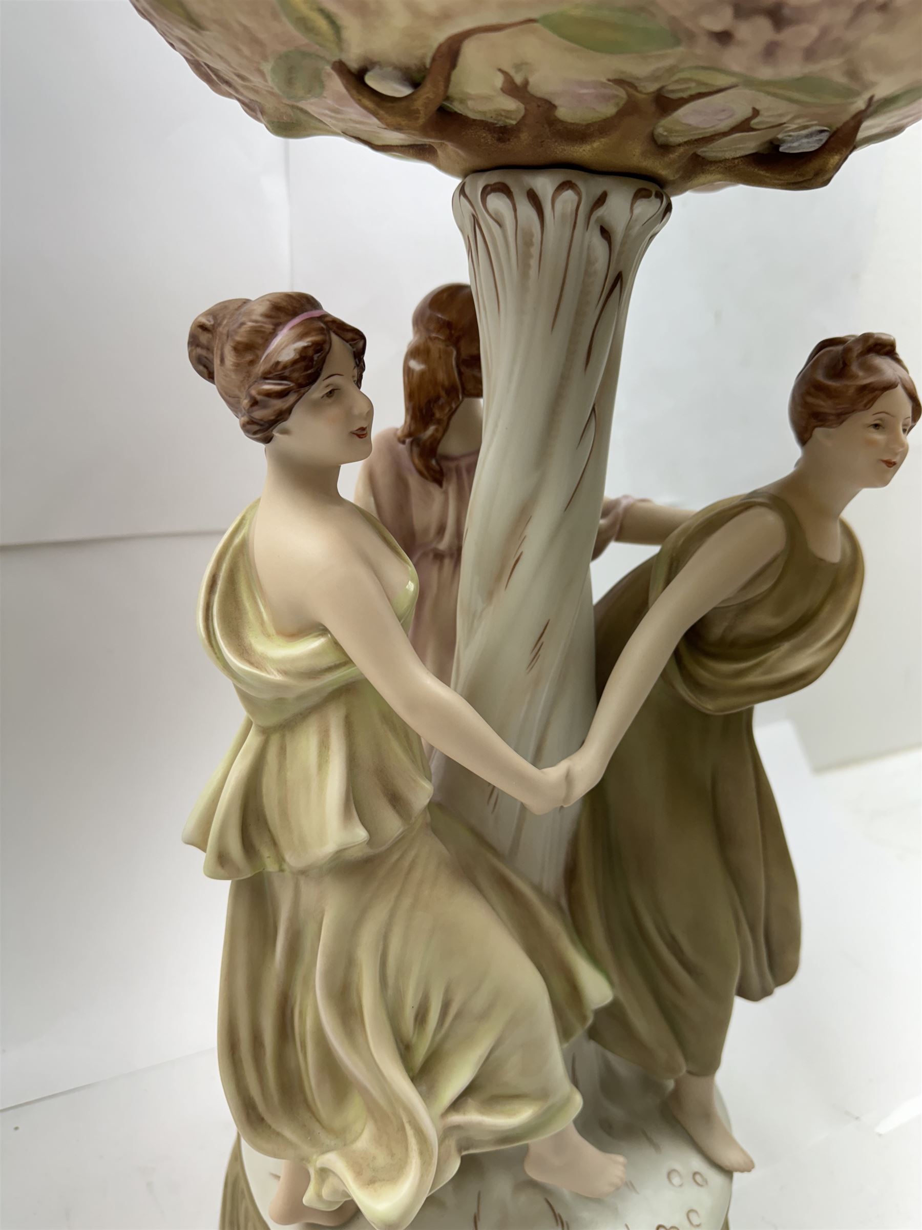 Royal Dux centrepiece, modelled as the Three Graces beneath a floral compote, upon a circular base, H51cm