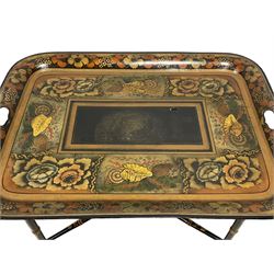 19th century tole ware tray of rectangular form, decorated with Japanese inspired floral motifs and gilt shells, with pierced handles, the associated ebonised and gilt stand, raised on ring turned splayed supports united by X-stretcher, decorated with gilt foliage