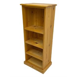 Narrow pine open bookcase, rectangular top over three shelves, on plinth base