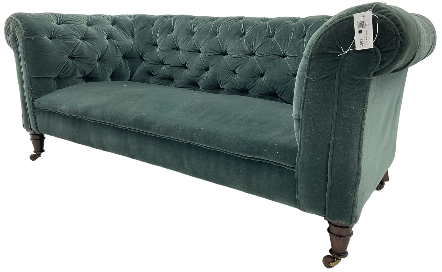 Victorian hardwood-framed Chesterfield sofa, traditional shape with low back and rolled arms, upholstered in teal buttoned fabric, on turned front feet with brass and ceramic castors 