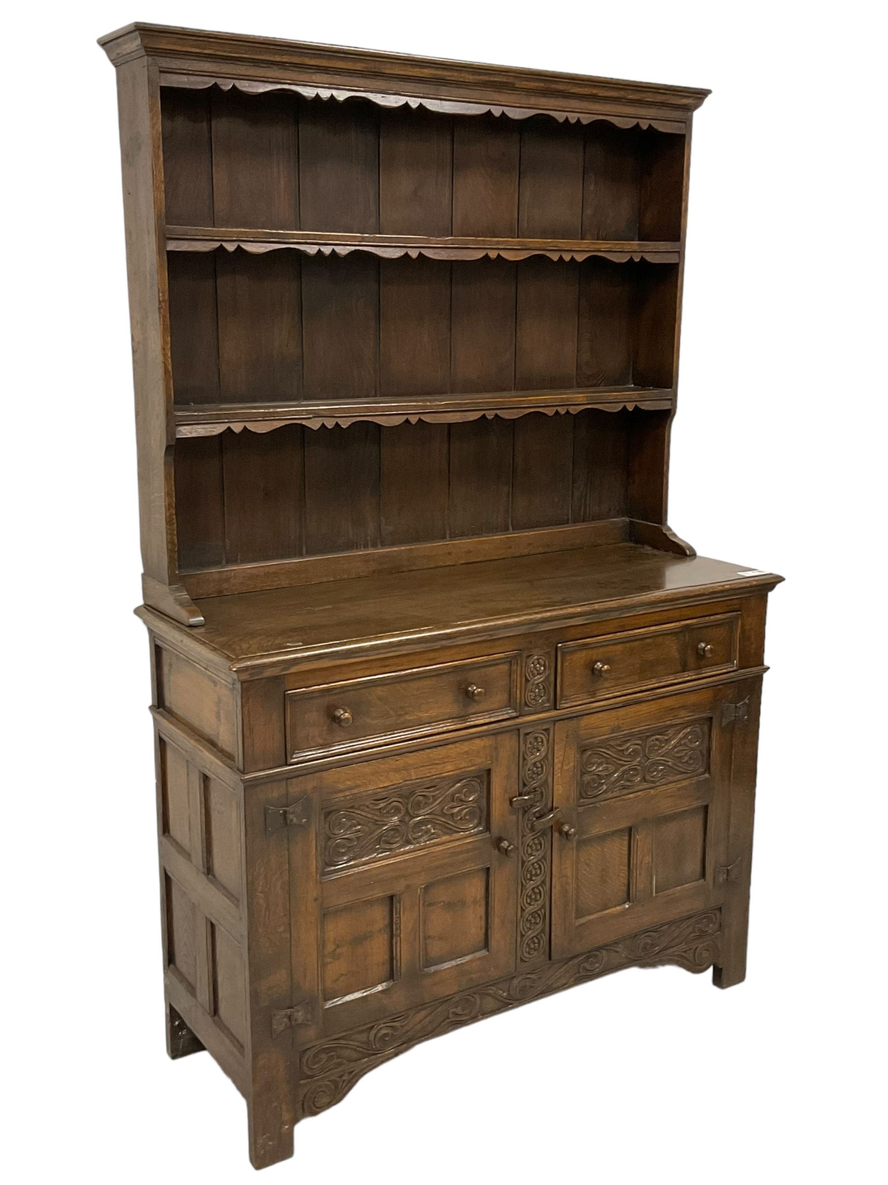 Georgian design oak dresser, two-tier plate rack with shaped aprons, the base fitted with two fielded moulded drawers, over two panelled cupboards carved with scrolling acanthus leaves, with guilloche carved central upright, on stile feet