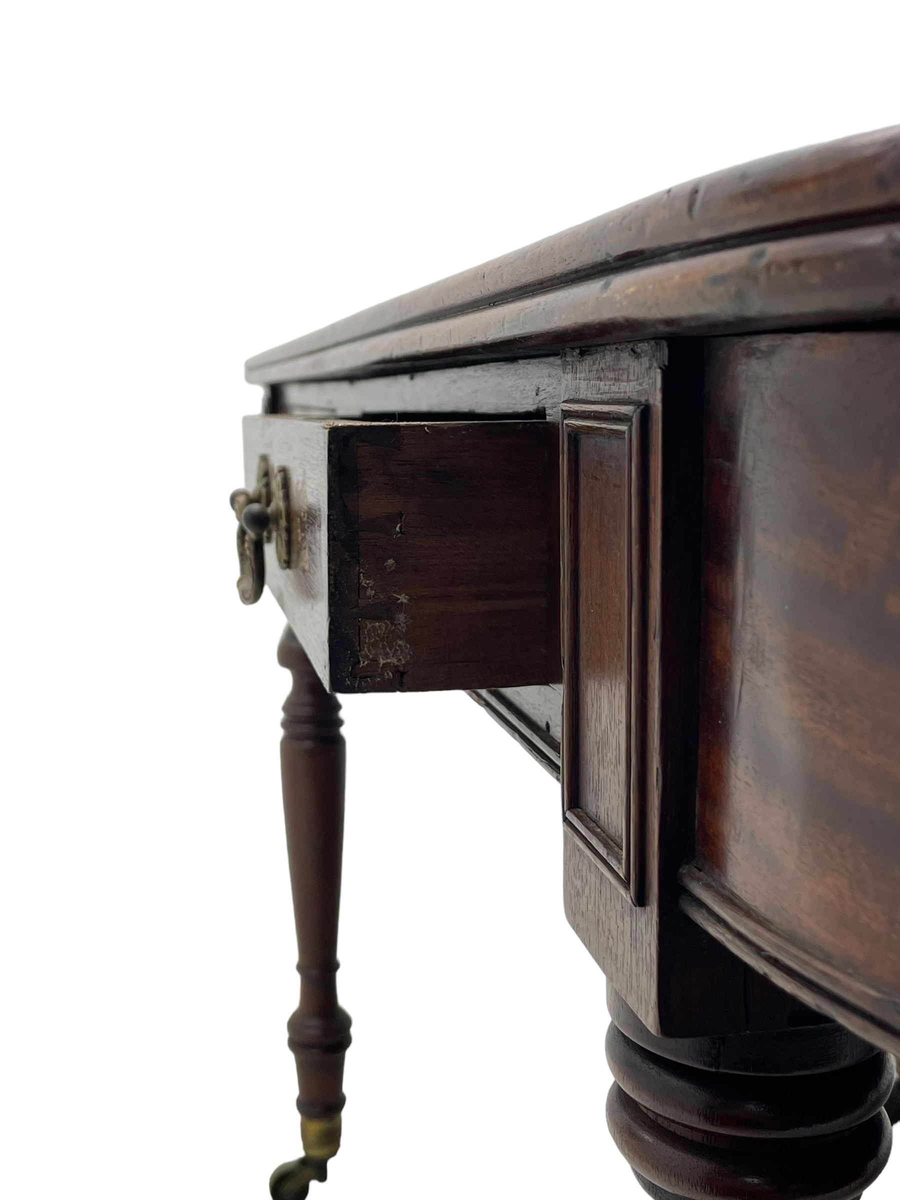 George III mahogany extending dining table, reed moulded rectangular top with rounded corners, two D-ends each fitted with two drawers, two additional leaves, on turned supports with ribbed brass cups and castors 