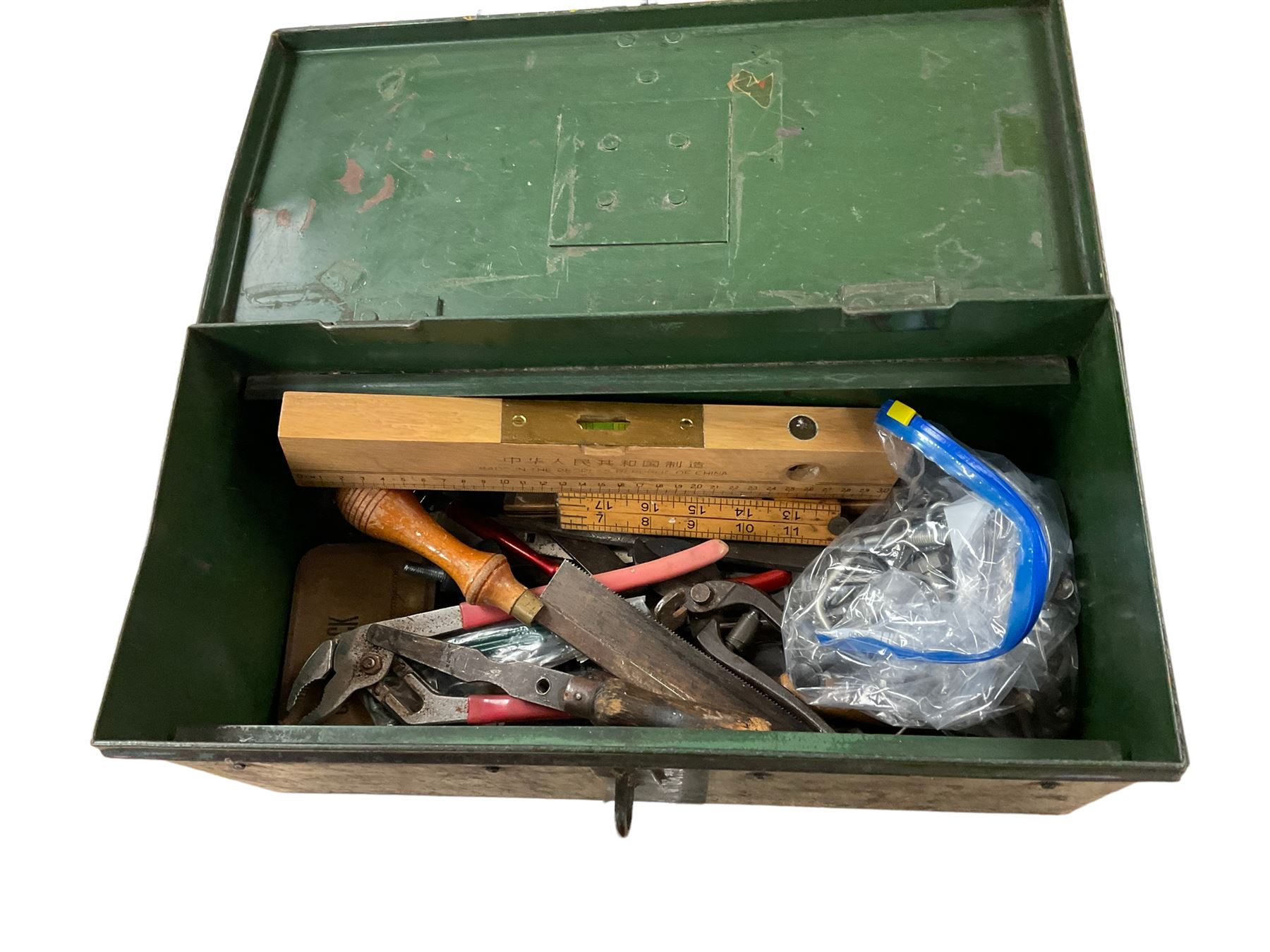 Green tin box of tools, including saws, spanners etc