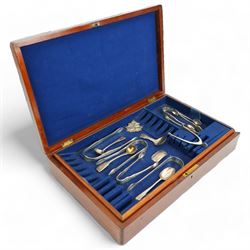 Three pairs of early 19th century engraved silver sugar tongs, three later pairs,  pair of silver wishbone nips, William IV caddy spoon and Hollands decanter label and three other items in a mahogany cutlery box