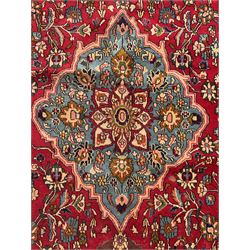 Central Persian Isfahan crimson ground carpet, central floral medallion in ivory and blue, set within a field of dense floral patterns, bordered by a navy band decorated with stylised flower heads and vines