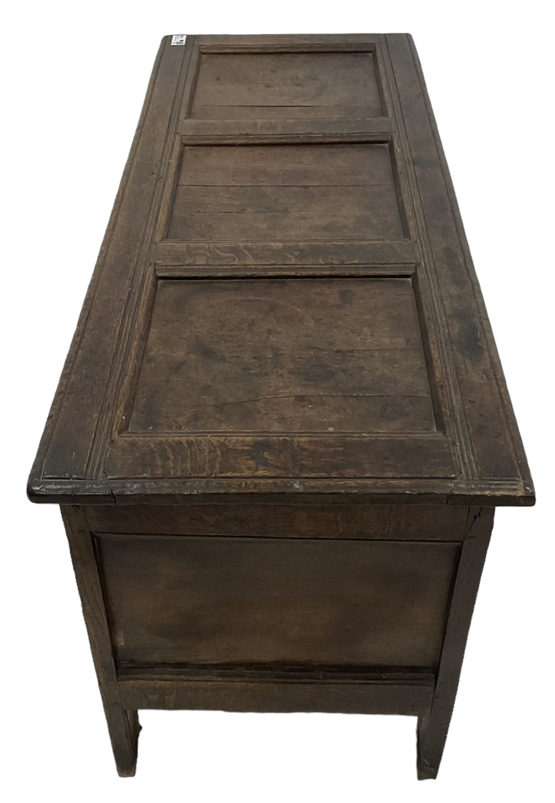 18th century oak coffer or chest, rectangular hinged panelled top with moulded frame enclosing candle box, the frieze carved with foliate S-scrolls over a quadruple panel front decorated with carved lozenges, on stile supports