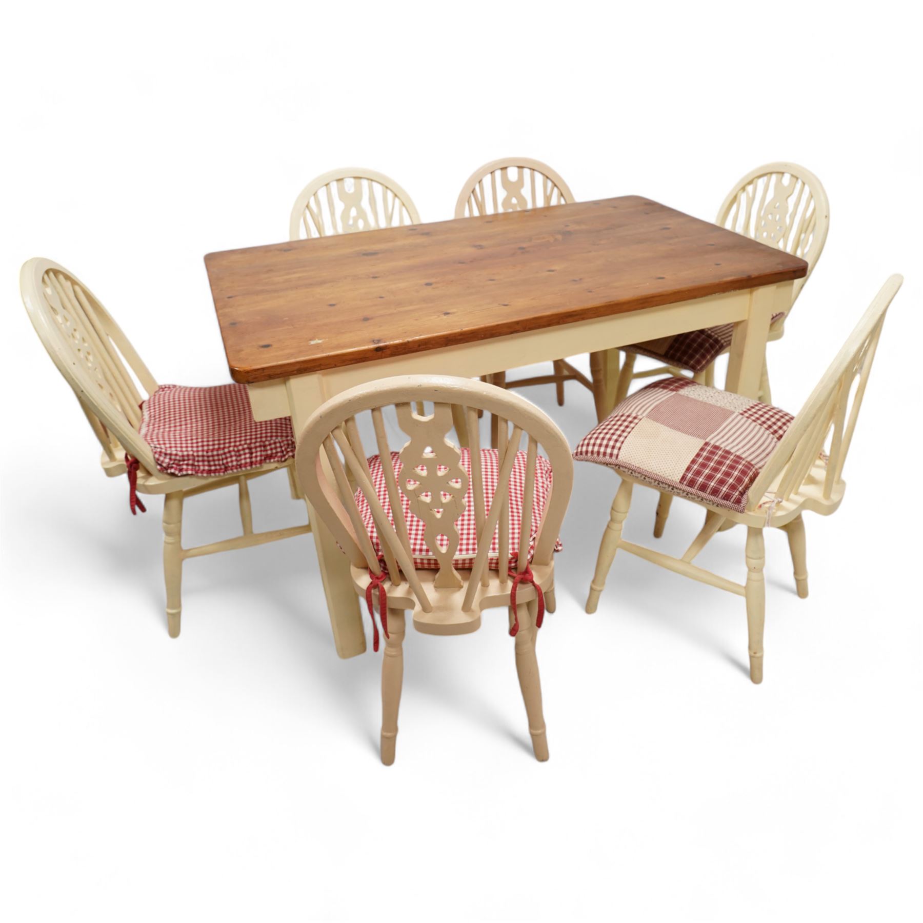 20th century pine kitchen dining table, stained top over cream painted base (W133cm D81cm H77cm); and six painted wheel-back chairs (H89cm)