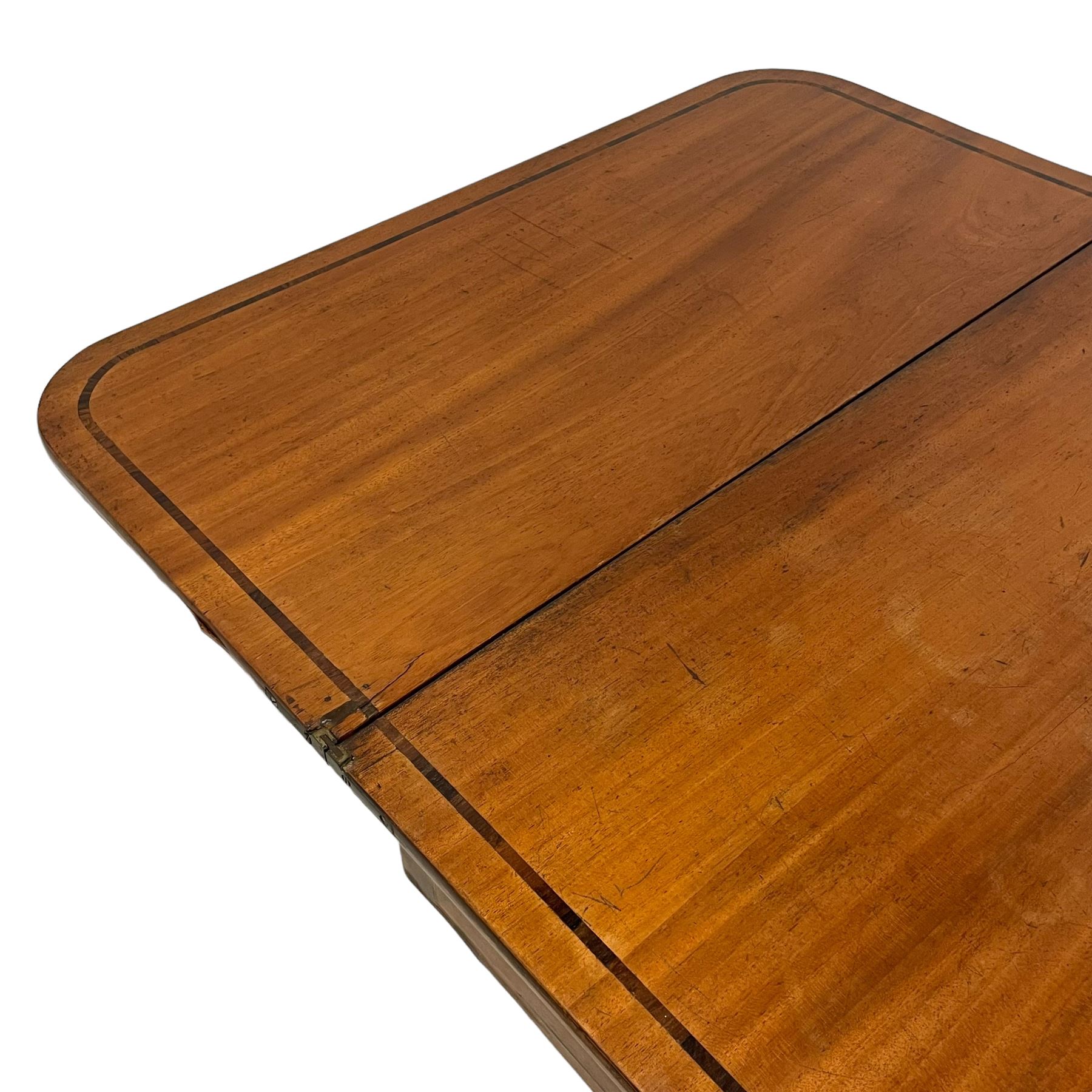 Early 19th century mahogany tea table, rectangular fold-over top with rounded corners, inlaid with mahogany banding, the plain frieze with mahogany stringing, raised on gate-leg action ring turned supports