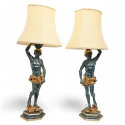 Pair of Italian figural carved table lamps, each modelled as a semi-nude male figure holdi...