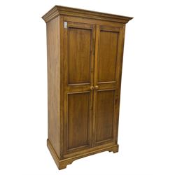 Hardwood double wardrobe, enclosed by two panelled doors, on bracket feet 