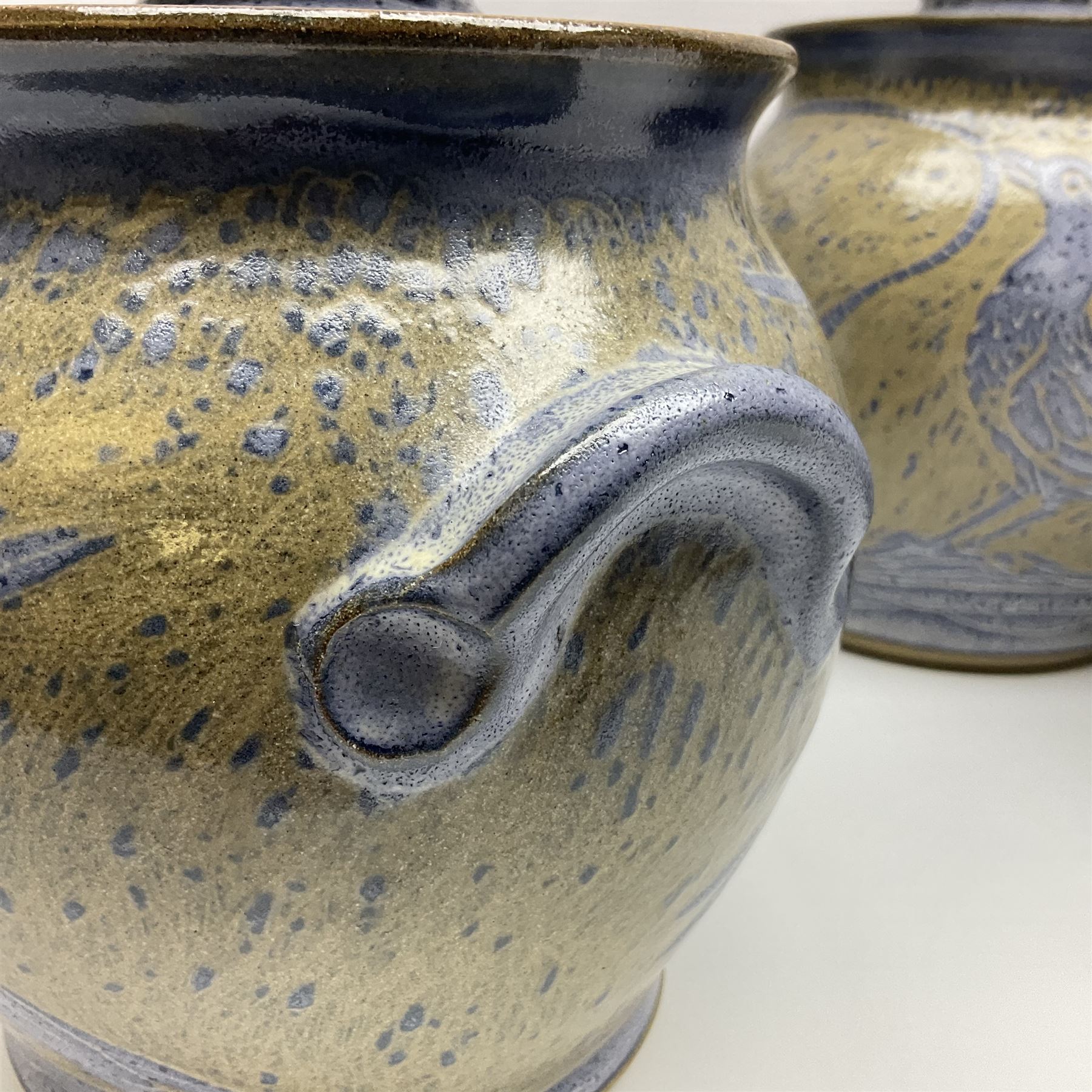 John Egerton (c1945-): set of five studio pottery stoneware twin handled jars with covers, decorated with blue birds upon a brown mottled ground, H20cm