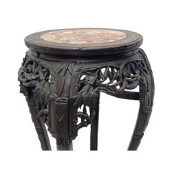 Early 20th century Chinese hardwood plant stand, circular top with marble inset, carved and pierced with interlacing foliage, on leaf carved supports united by x-framed stretchers