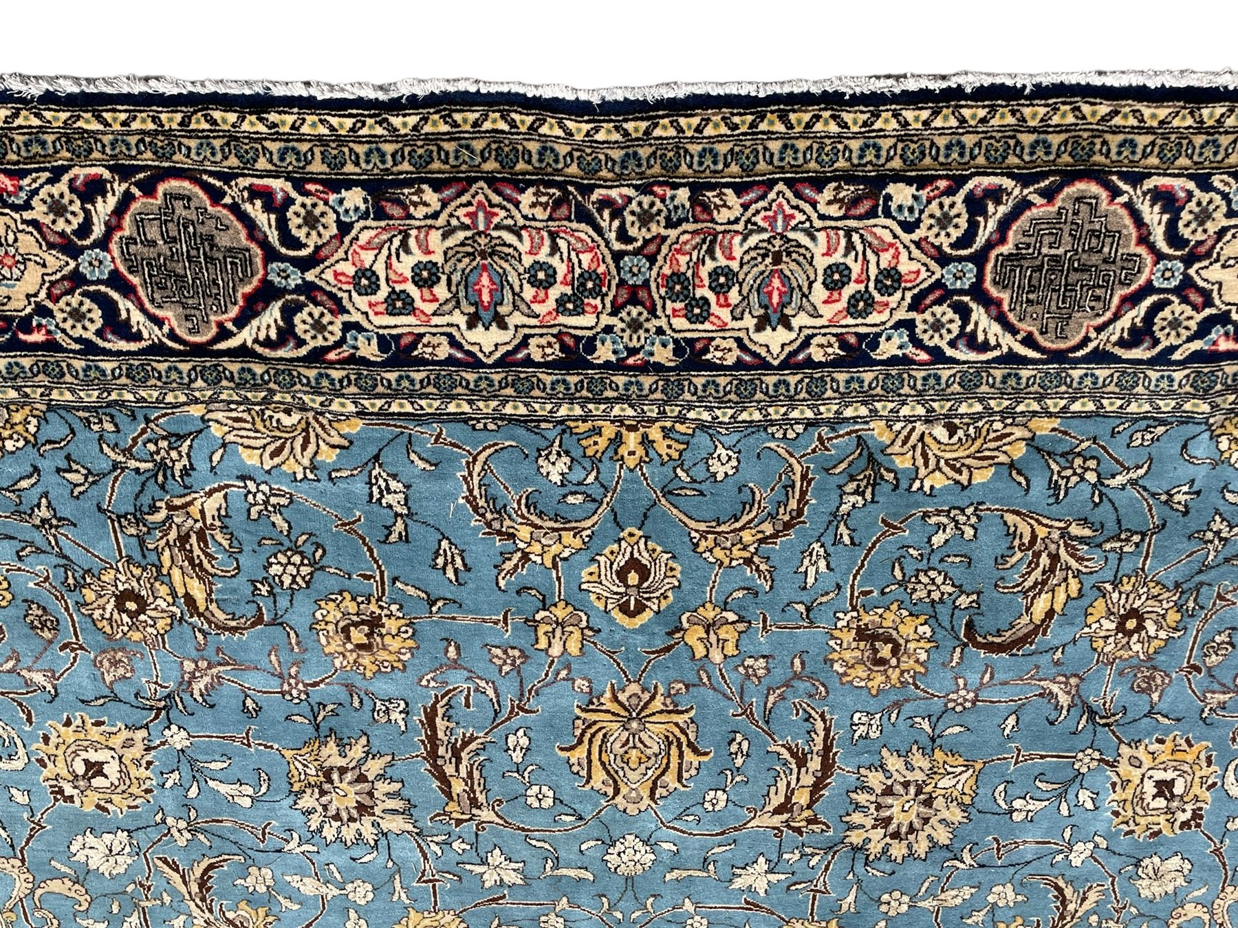 Persian Nain blue ground rug, overall arabesque design, the busy field decorated with interlacing branches and palmettes, indigo ground border with panels decorated with knots and lotus flower motifs, surrounded by trailing branches and flower heads, within guard stripes