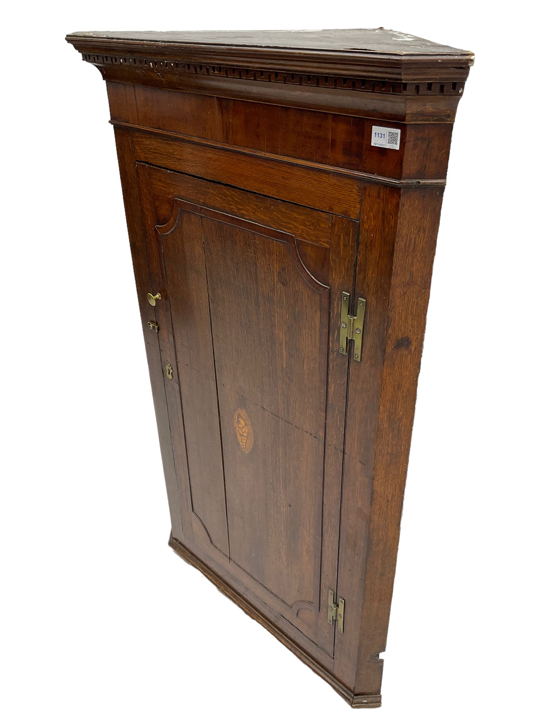 George III oak and mahogany wall hanging corner cupboard, single door decorated with central inlaid shell motif enclosing three shelves