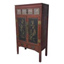 Late 19th century Chinese Qing dynasty red and black lacquered wood cabinet, Fujianese province, upper cupboard enclosed by two doors with relief carved and gilt panels depicting figures behind glass, the large cupboard enclosed by two panelled doors carved with trailing foliate branches and birds, inscribed with Chinese characters, to the left ‘Prolong life’ and to the right ‘Wealth and good fortune’, fitted with two drawers, square supports with carved brackets 