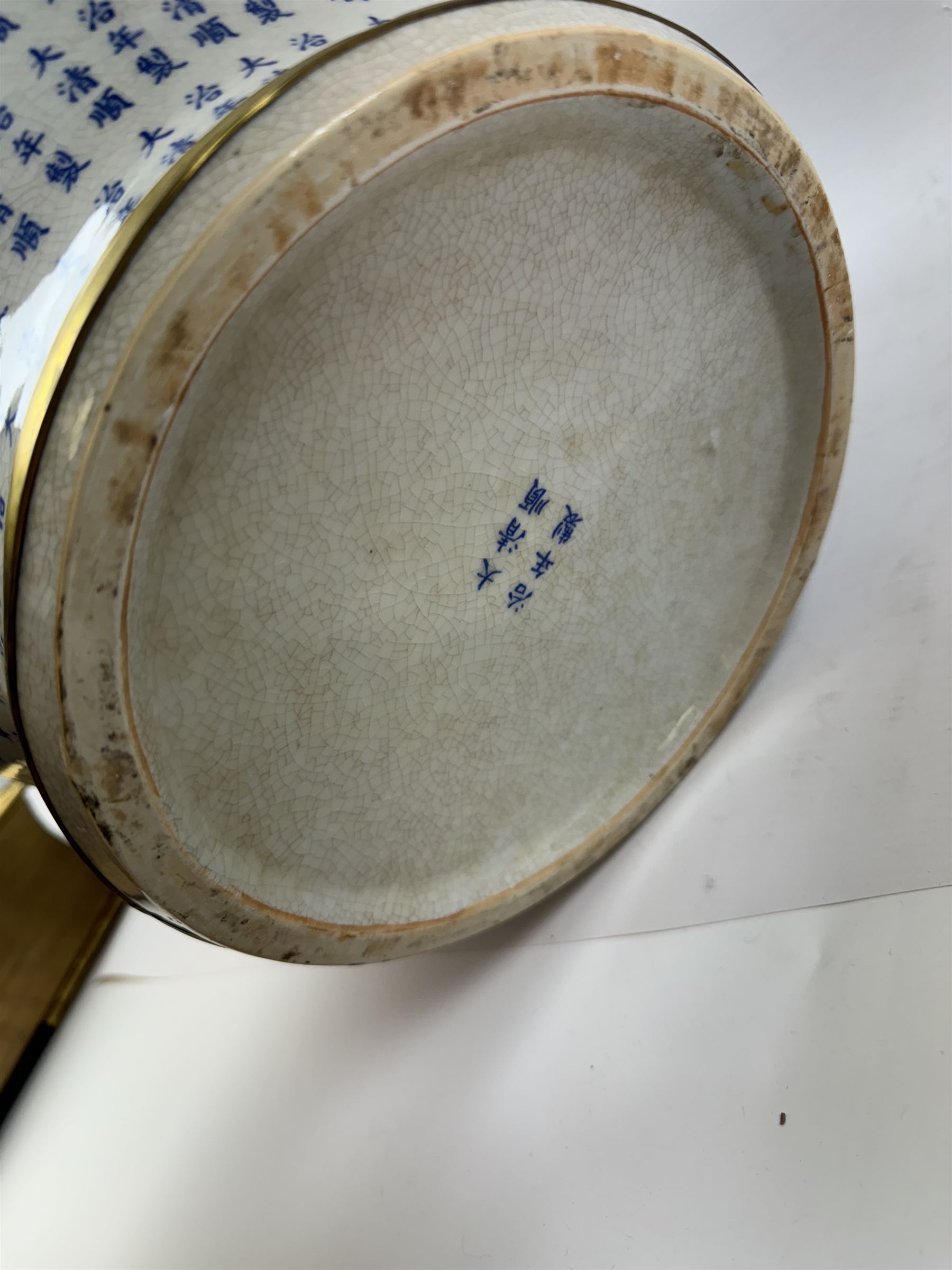 Large Oriental design ginger jar and cover, of squat baluster form with domed cover, decorated in blue with Chinese characters against a white crackle glaze ground, the cover, neck and foot rim with applied brass band, with character mark beneath, H43cm