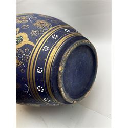 Large and unusual terracotta floor vase, of ovoid form with tall flared neck with frilled rim, decorated with stylised foliate motifs in gilt upon a dark blue ground, H89cm