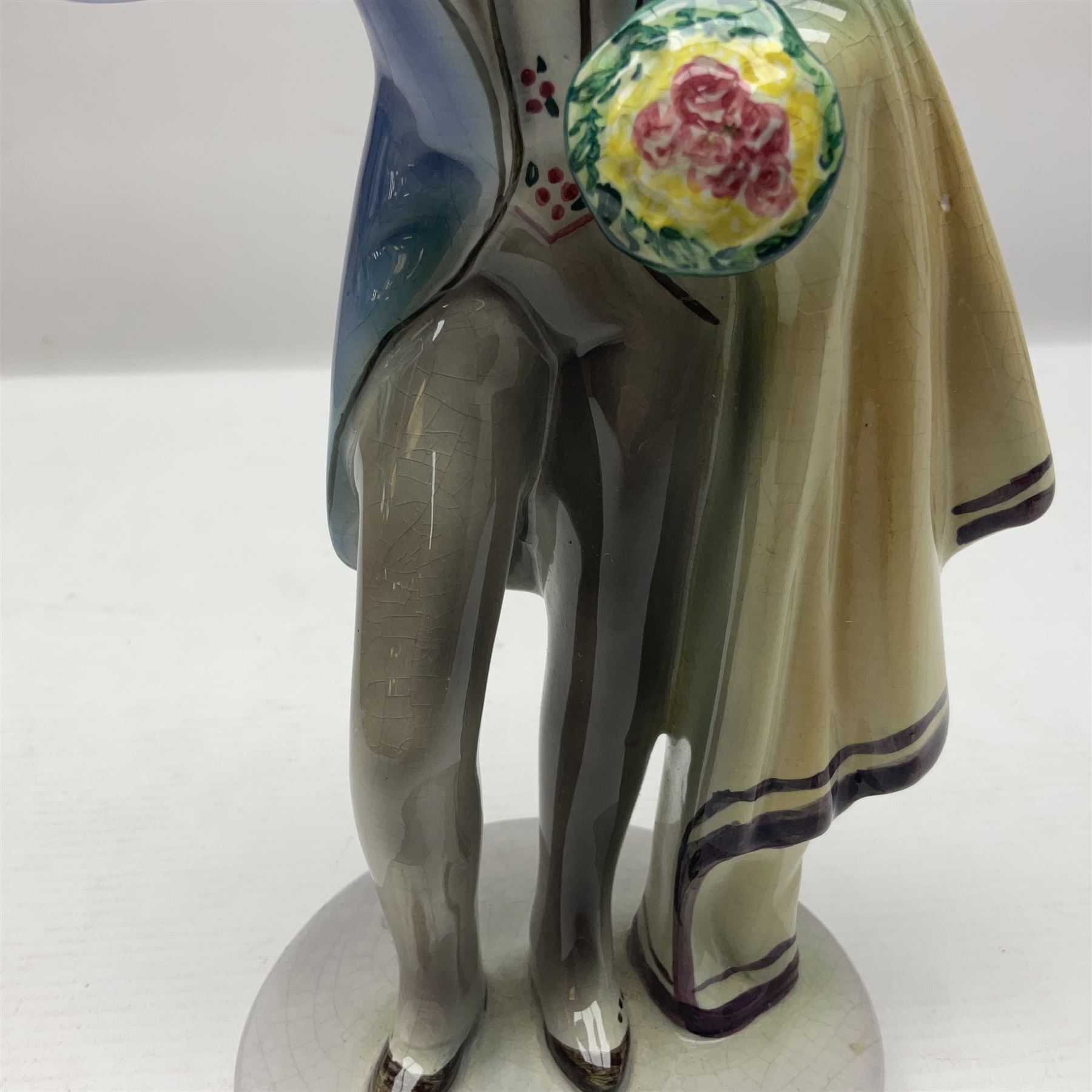 Goldscheider figure, modeled as a gentleman with flowers, upon a circular base, with printed mark beneath, H25cm