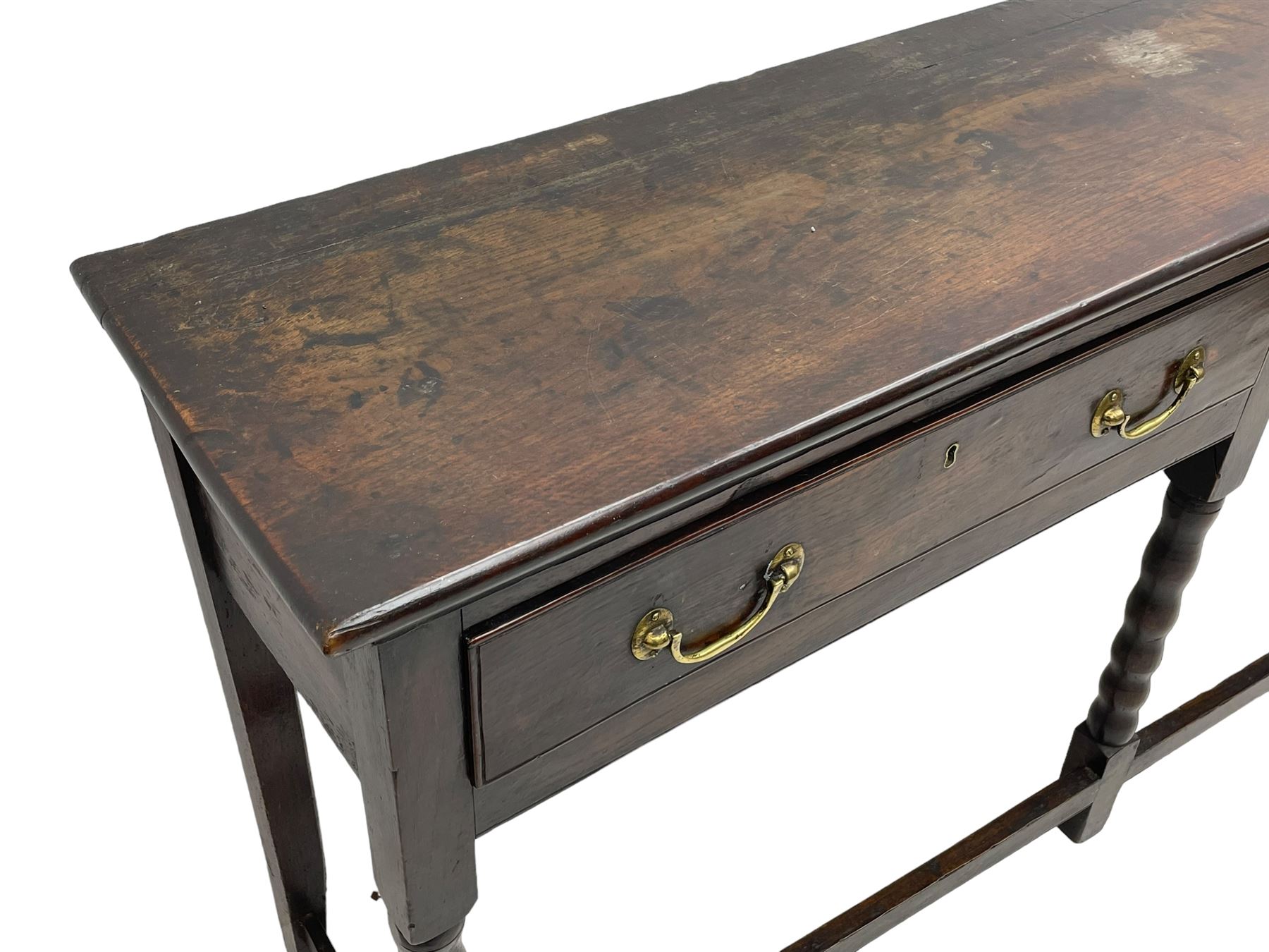 18th century oak dresser base, rectangular top, fitted with two drawers with moulded facia edges and brass swan neck handles, raised on turned front supports united by stretchers