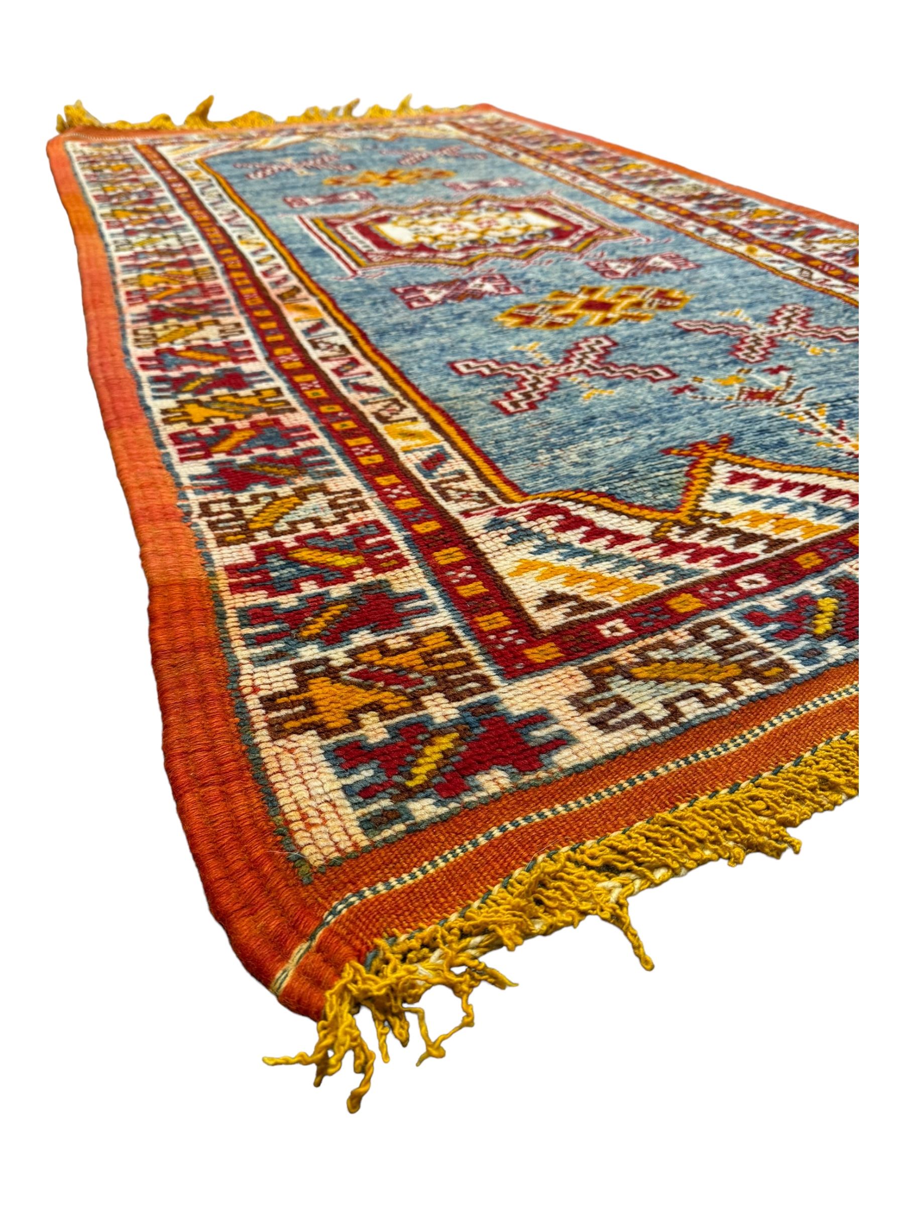 Persian Qashqai crimson ground rug, the field with central indigo and yellow medallion with geometric motifs, flanked by smaller medallions, border with repeating patterns (112cm x 200cm); Turkish Kazak light blue ground rug (109cm x 193cm); red ground runner with three octagonal medallions (69cm x 138cm)