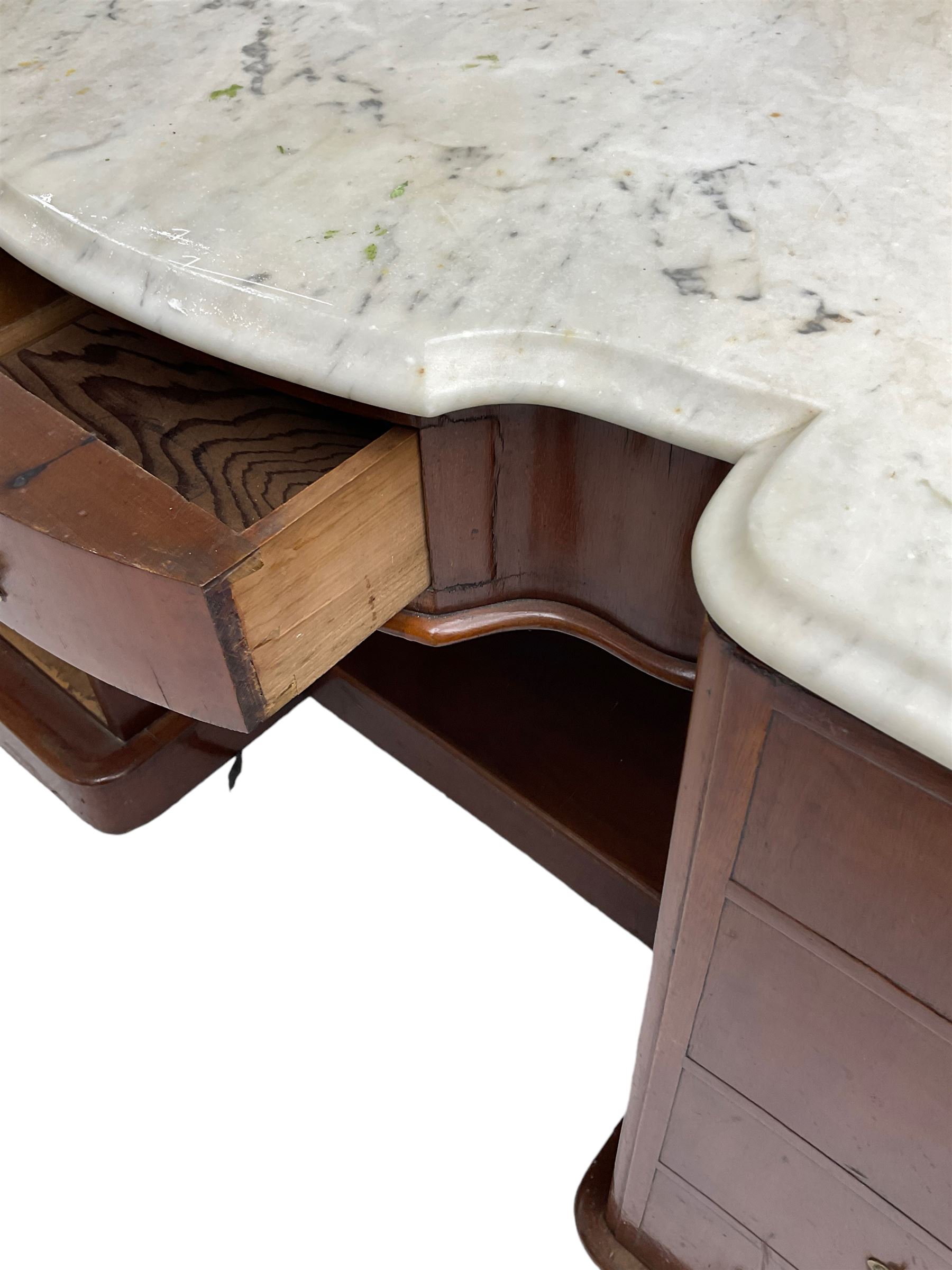 Victorian mahogany washstand table, shaped white marble top with raised back, fitted with shaped bow-front frieze drawer flanked by two cupboards disguised as eight graduating drawers with shell decorated pressed brass handle plates