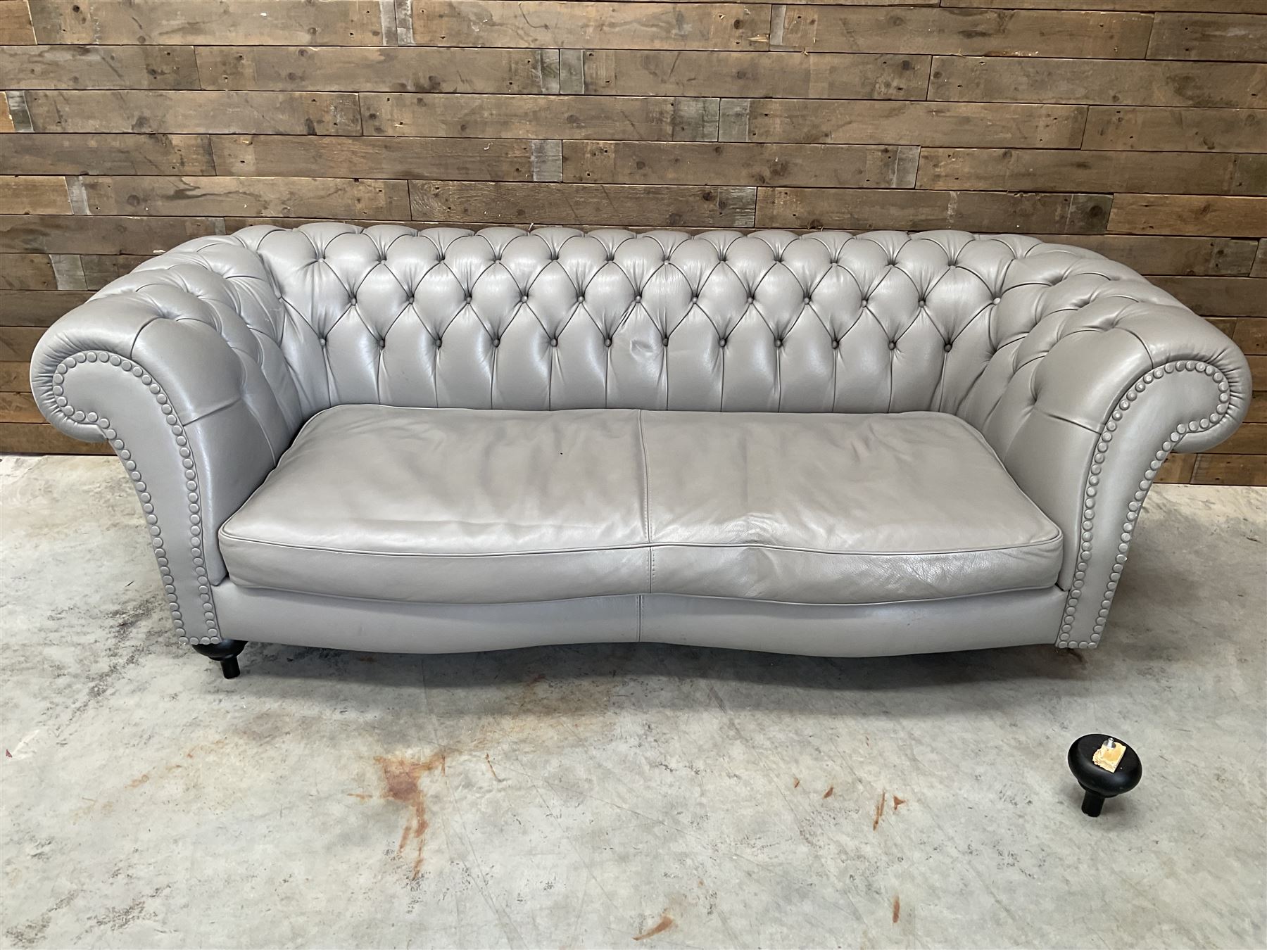 Three seat Chesterfield sofa, upholstered in grey buttoned leather - damaged leg