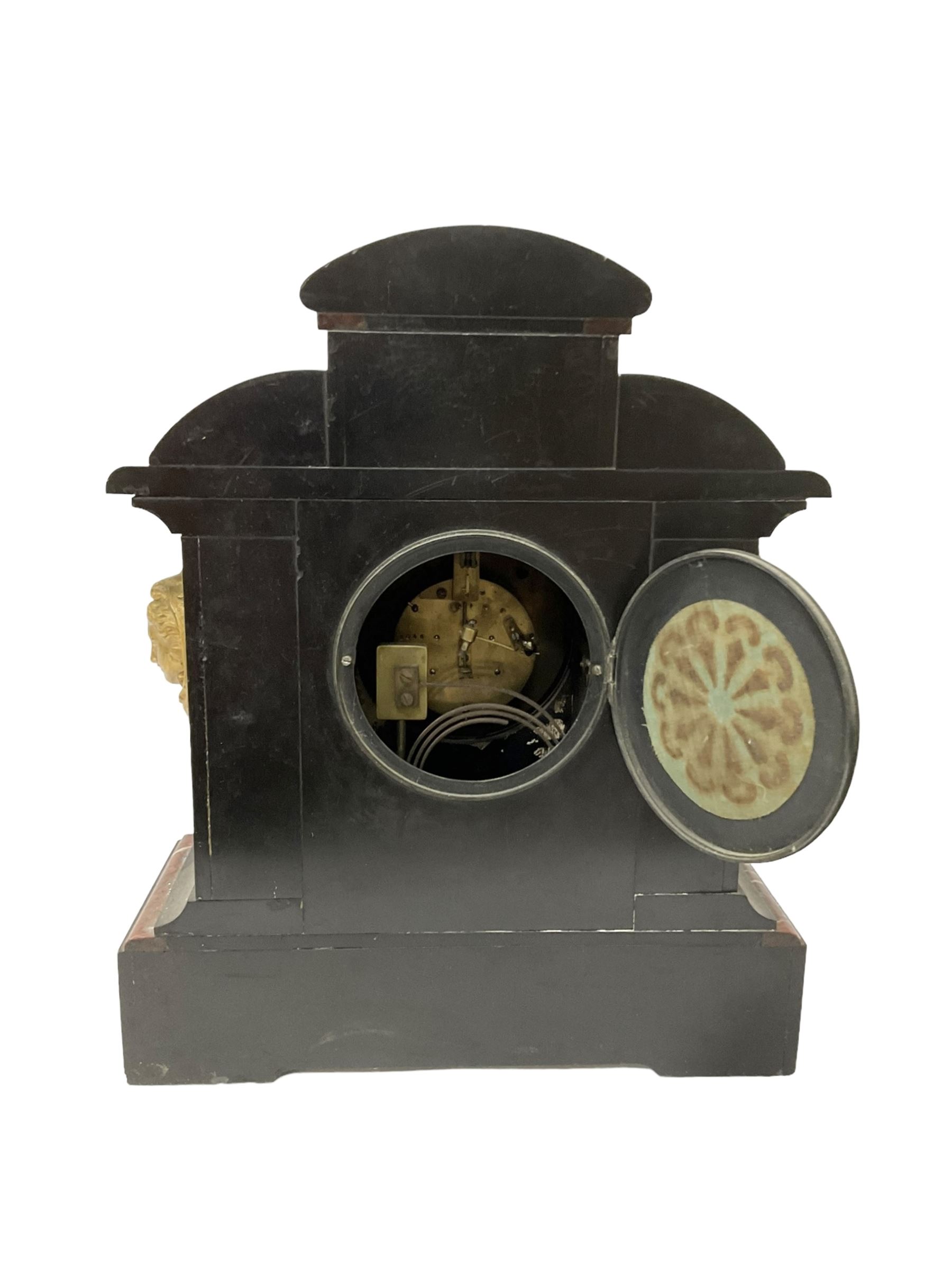 French - late 19th century 8-day Belgium slate mantle clock with incised decoration and contrasting rouge marble inlay, with a gilt repoussé panel to the front and cast cryatid to the sides, two part dial with a gilt centre, Arabic numerals, minute markers and brass fleur di Lis hands, twin train rack striking movement, striking the hours and half hours on a coiled gong. With pendulum. 