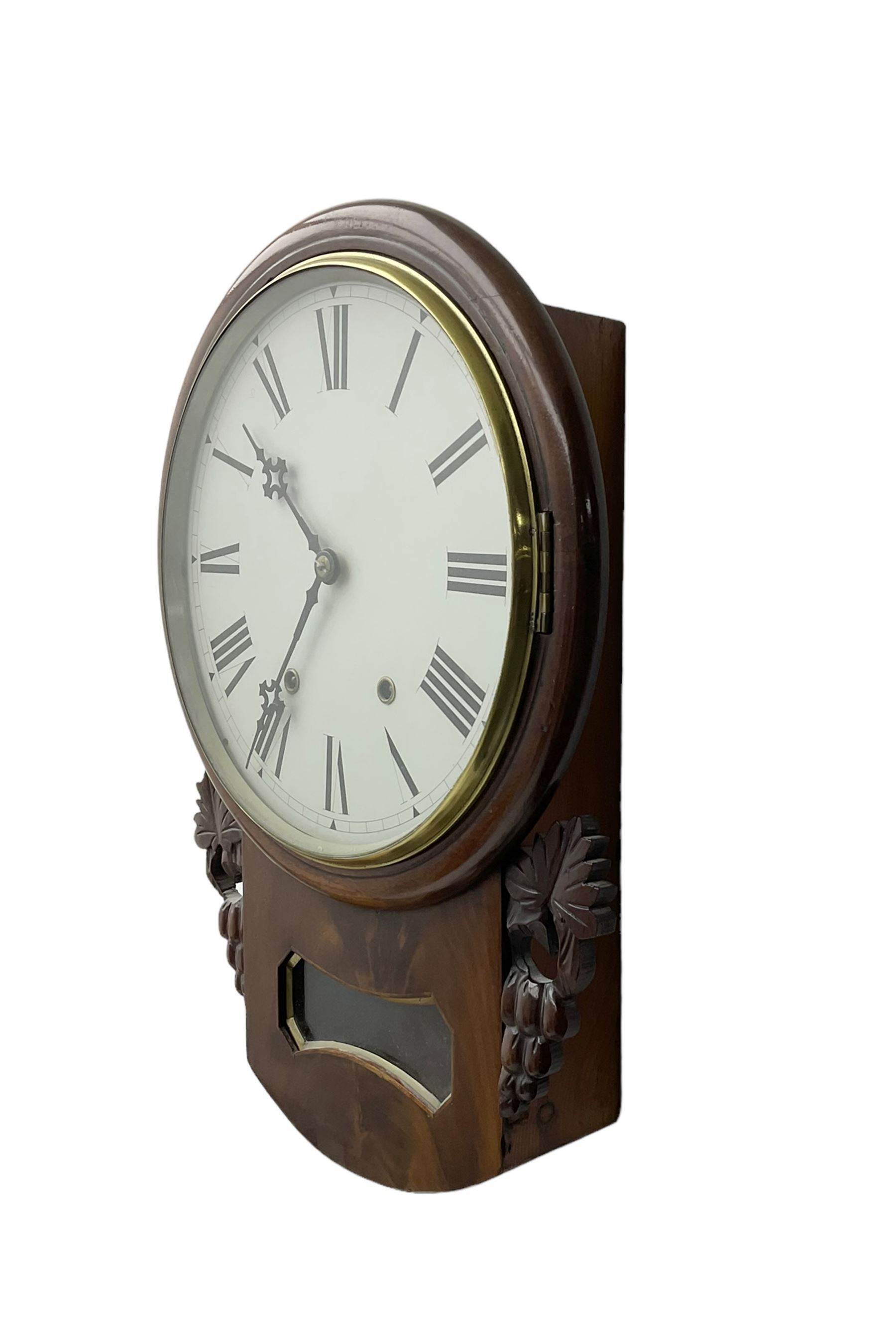 Late 19th century 8-day  drop dial wall clock in a mahogany case, carved ear pieces and glazed pendulum viewing glass, 12” painted dial with Roman numerals and Maltese steel hands, twin train going barrel movement striking the hours on a bell. No pendulum or key.