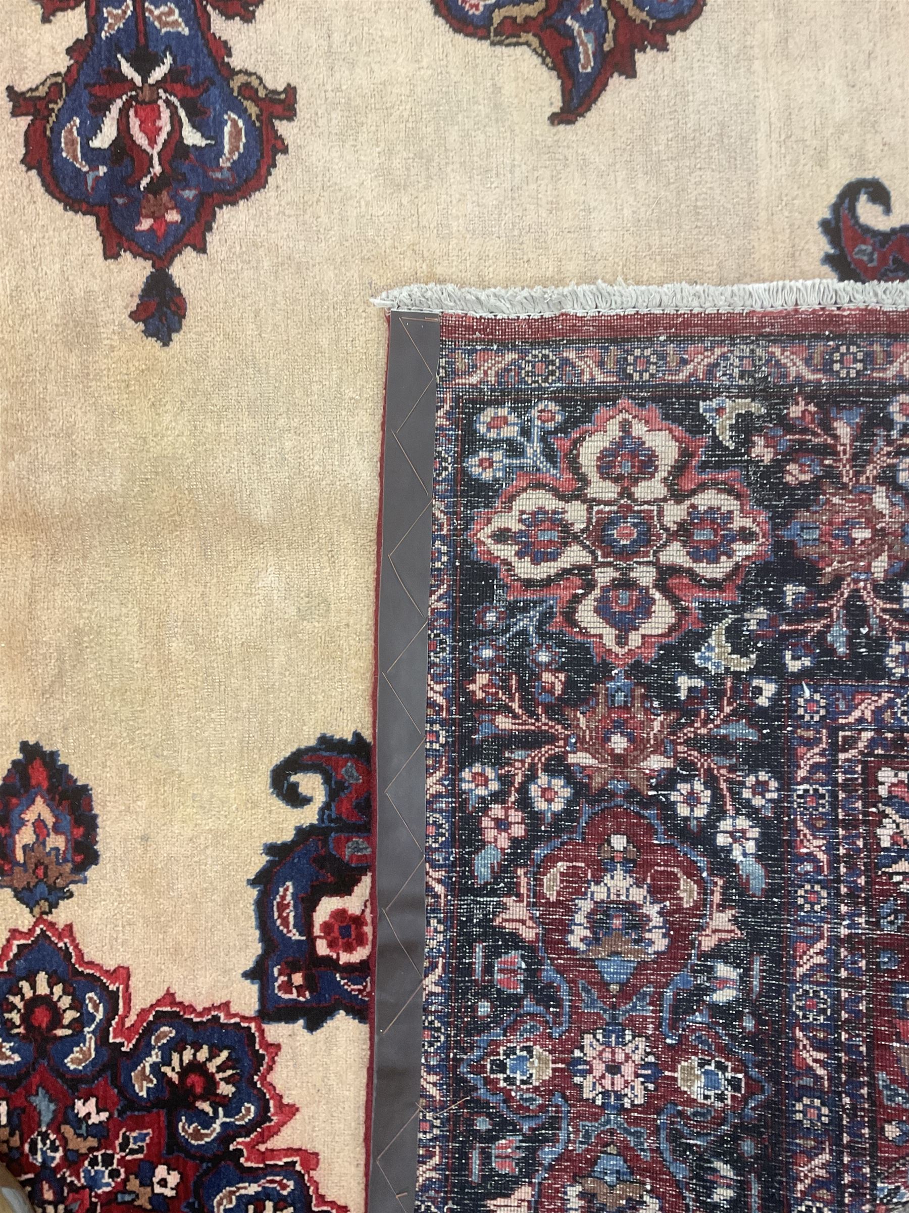 North East Persian Meshed carpet, the field with large central medallion decorated with stylised plant motifs, the field surrounded by panels, medallions and spandrels decorated with floral motifs, indigo ground border with overall floral design 