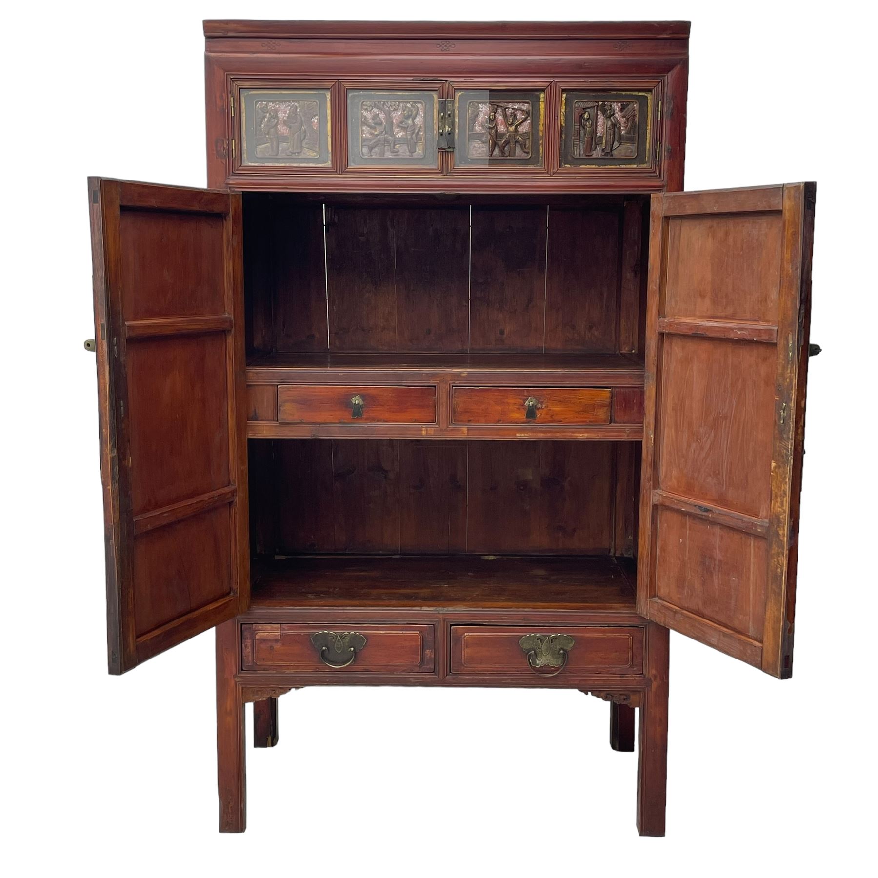 Late 19th century Chinese Qing dynasty red and black lacquered wood cabinet, Fujianese province, upper cupboard enclosed by two doors with relief carved and gilt panels depicting figures behind glass, the large cupboard enclosed by two panelled doors carved with trailing foliate branches and birds, inscribed with Chinese characters, to the left ‘Prolong life’ and to the right ‘Wealth and good fortune’, fitted with two drawers, square supports with carved brackets 